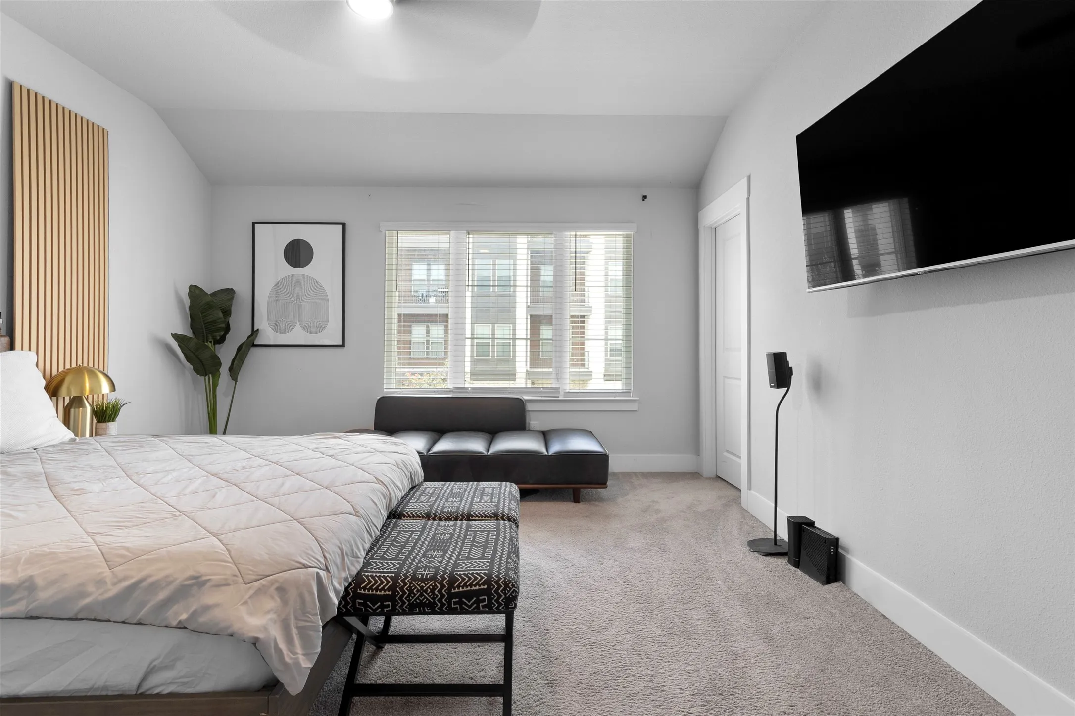 Spacious room featuring light-colored carpeting, a ceiling fan, and bright white walls