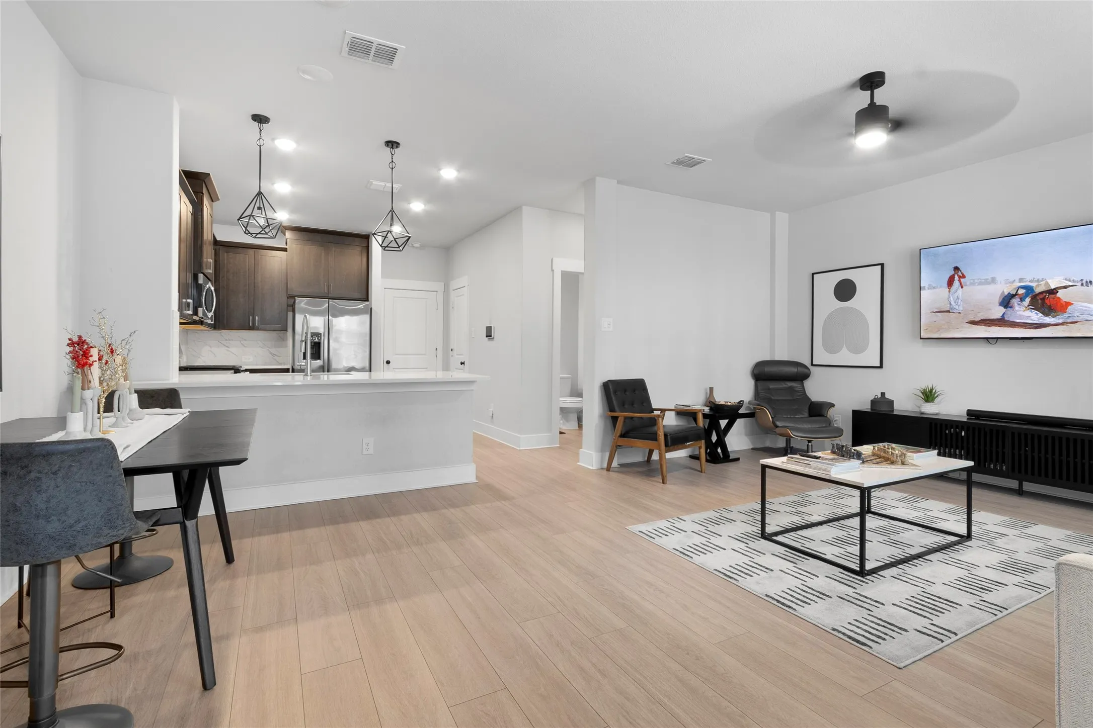 Open-concept living space featuring wood-finish flooring, recessed lighting, and a contemporary ceiling fan