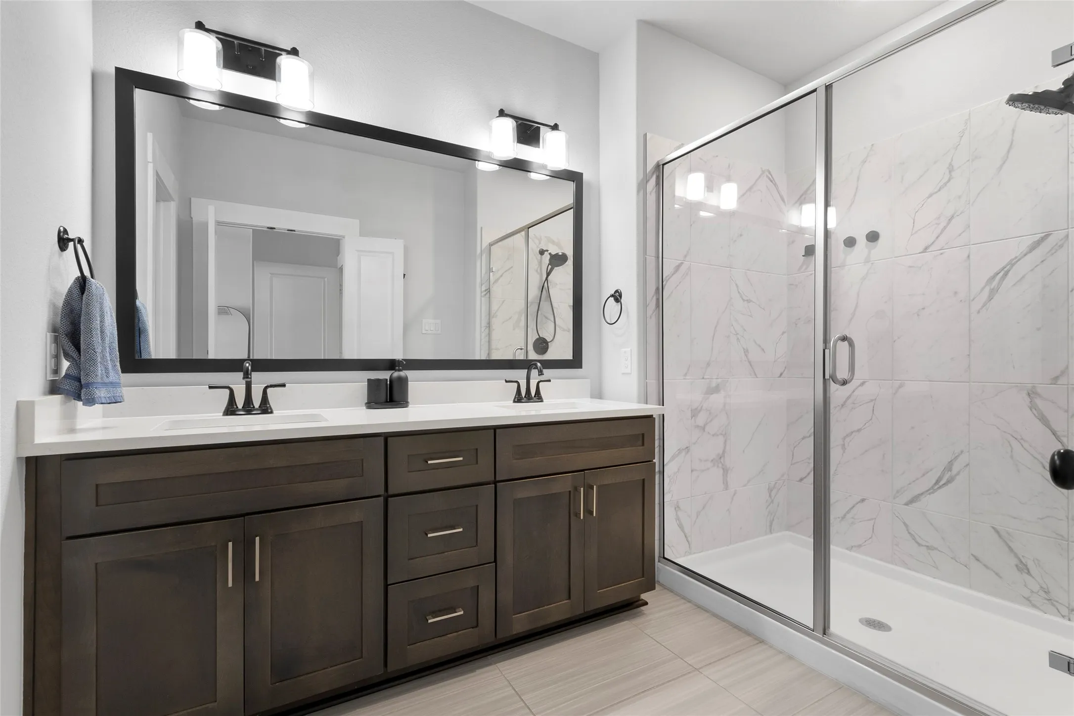 Double vanity with a white countertop and dark wood-finish cabinetry
