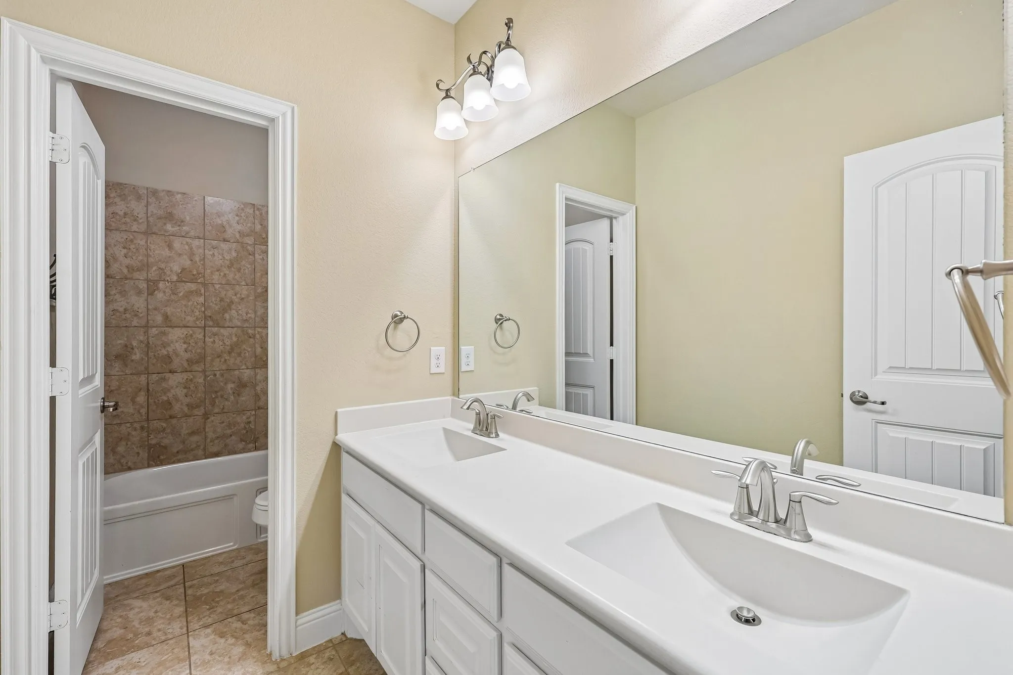 Dual vanity with integrated sinks and brushed nickel fixtures