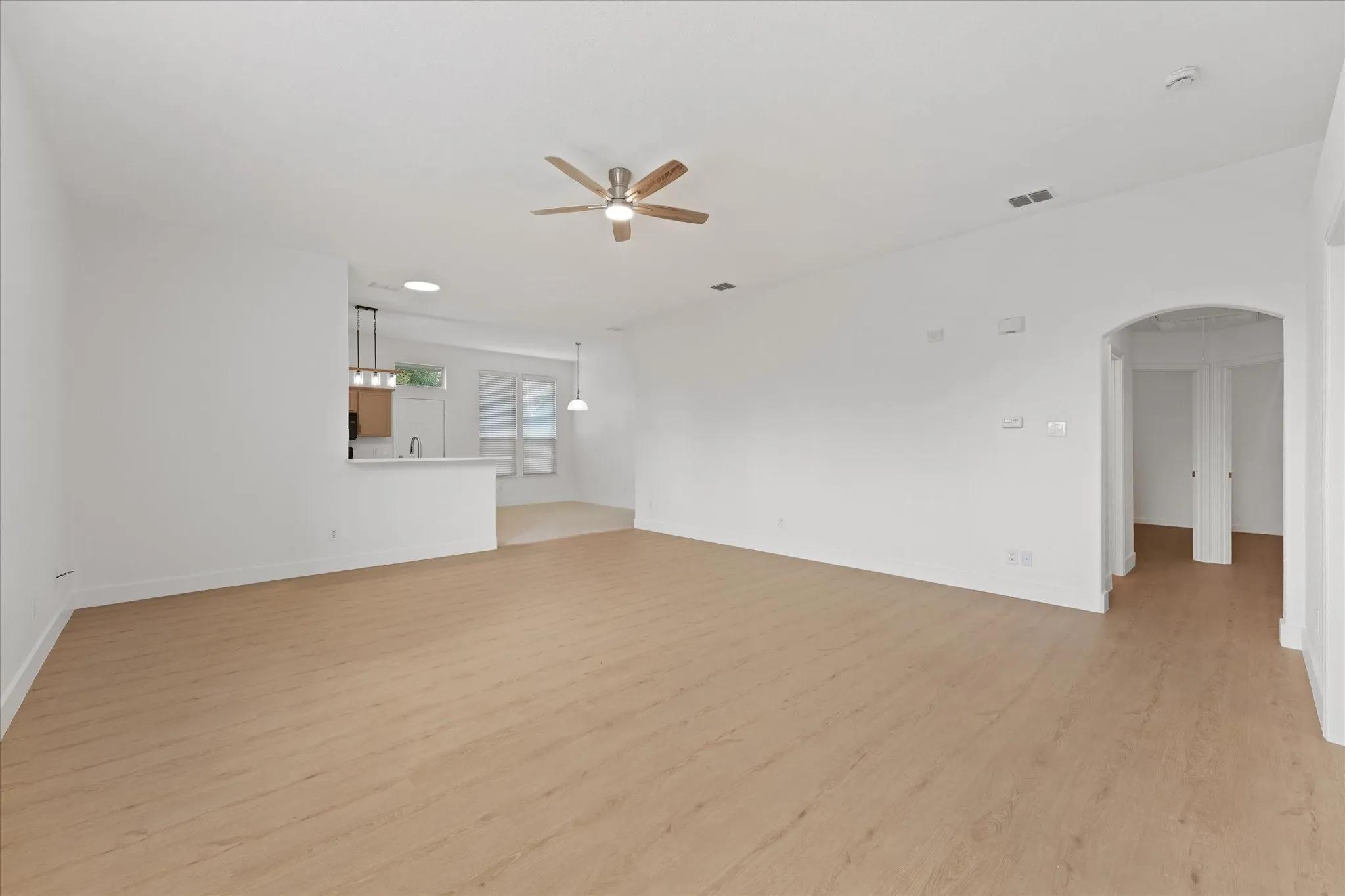 Living area facing hallway to bedrooms, laundry room and garage door