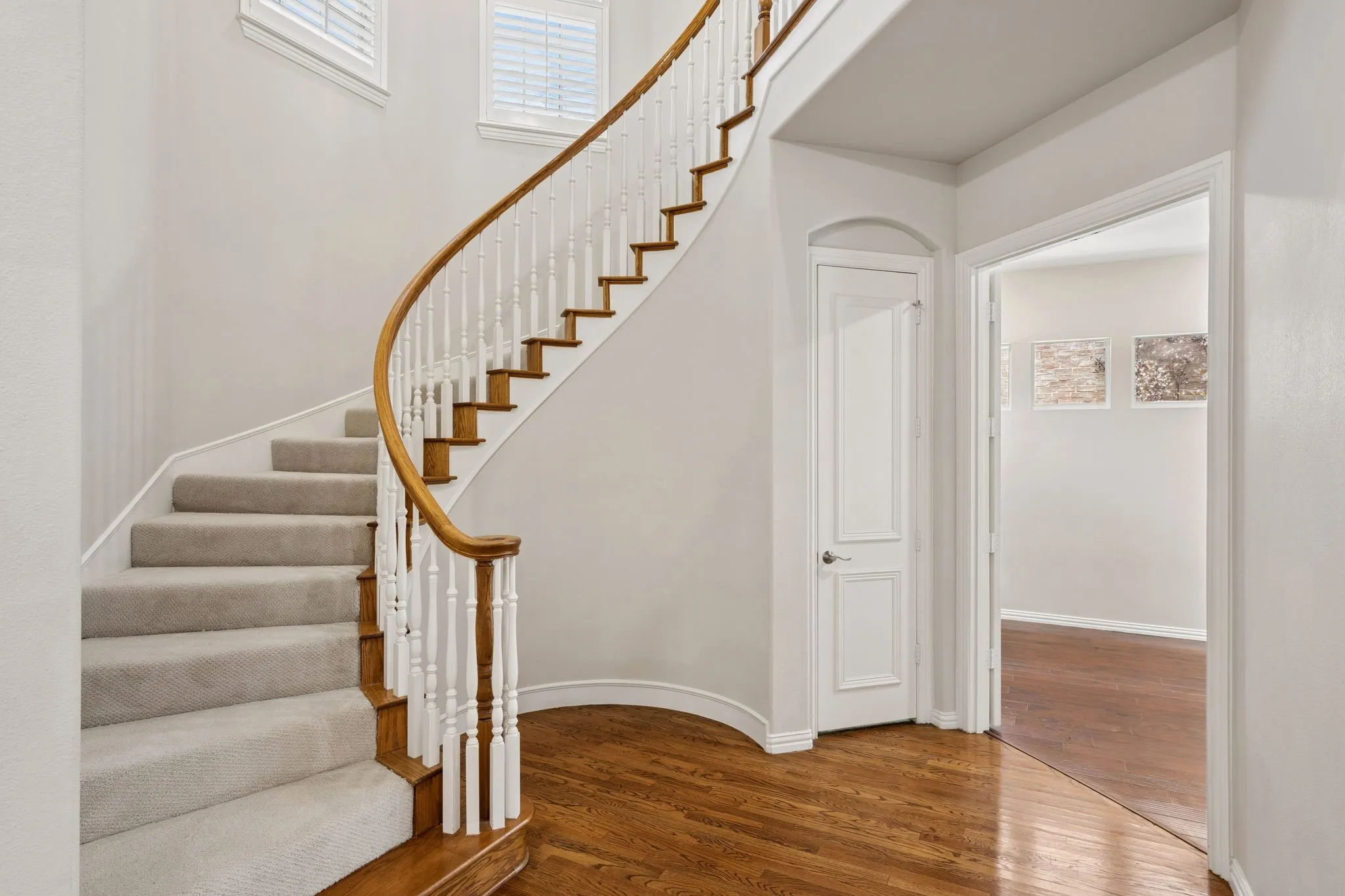 Circular staircase in entry foyer with new carpet and arched windows