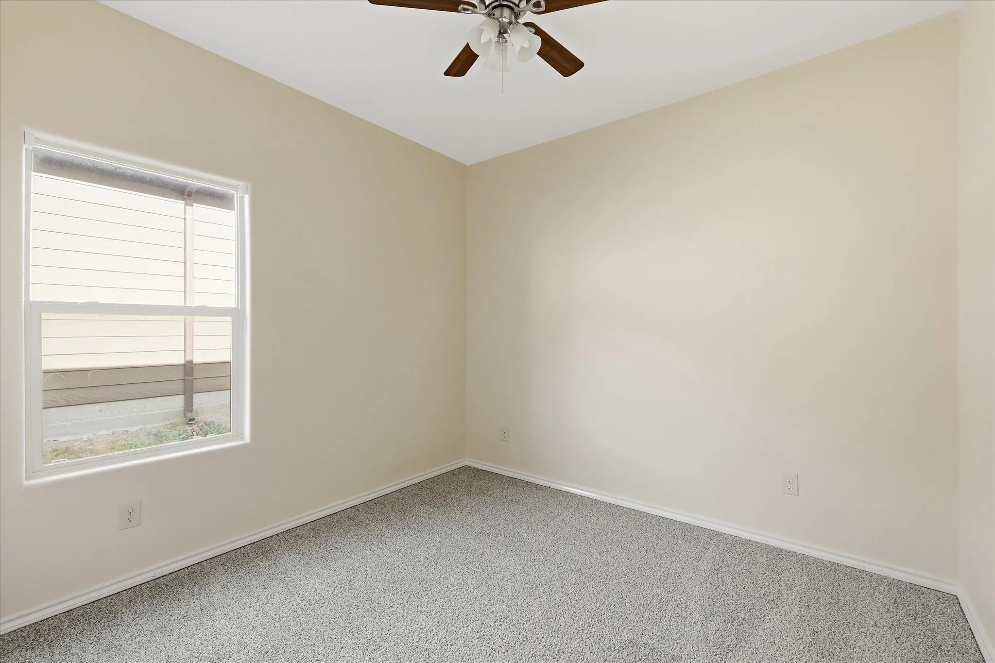 Room featuring neutral painted walls, light gray carpeting, and white baseboards