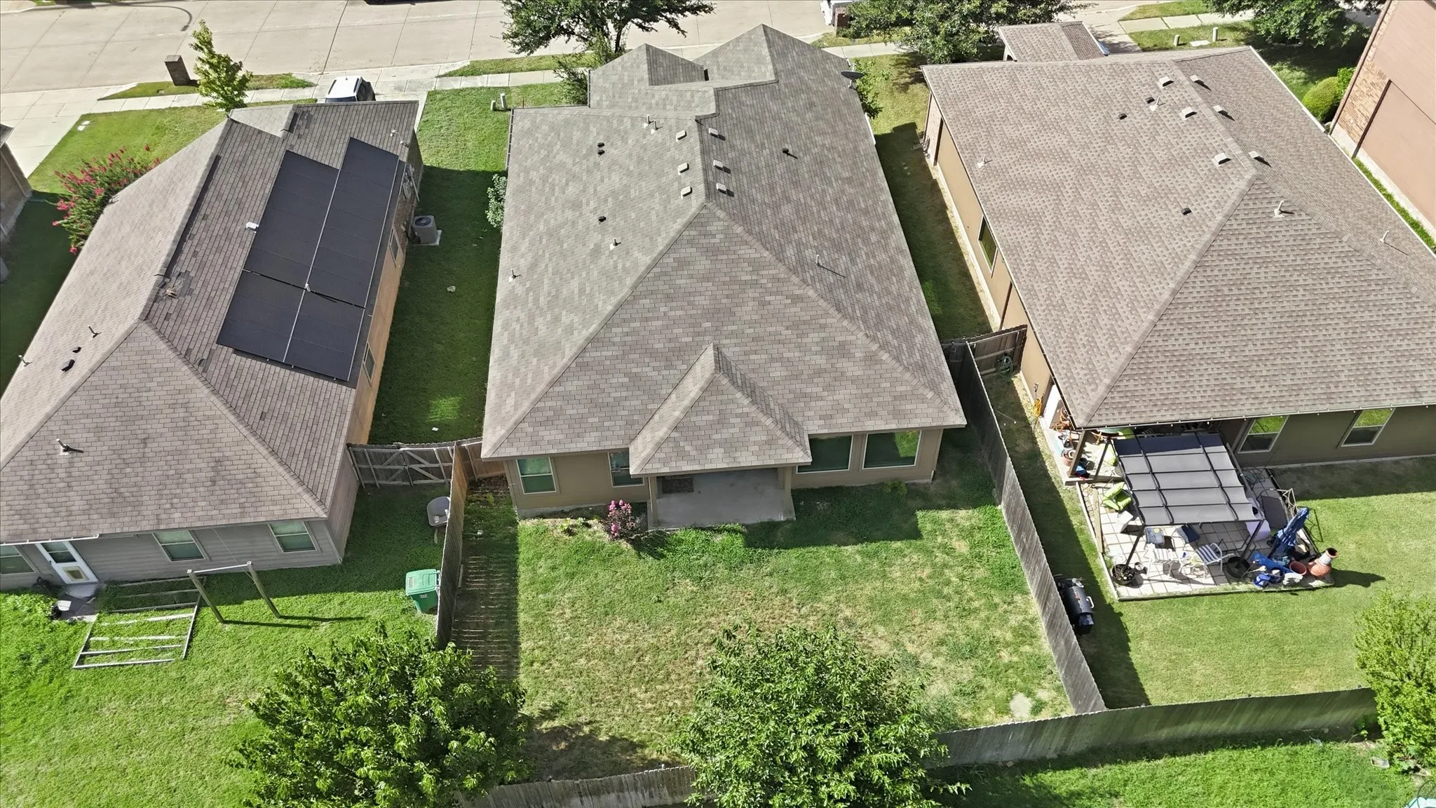 Spacious backyard featuring a covered patio, a privacy fence, and a large grassy area