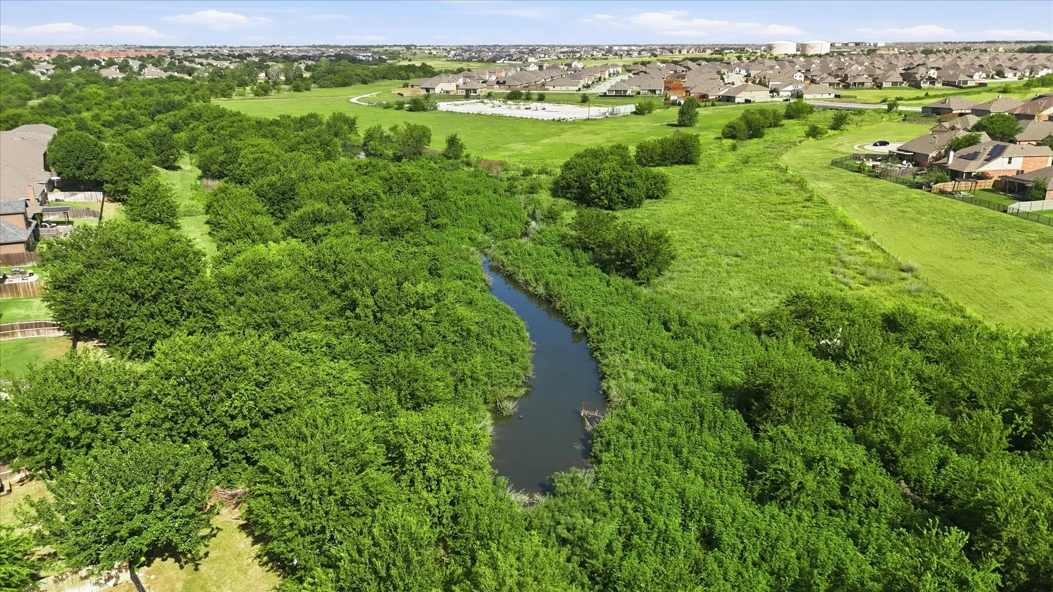 Natural landscape featuring a winding waterway bordered by dense green foliage