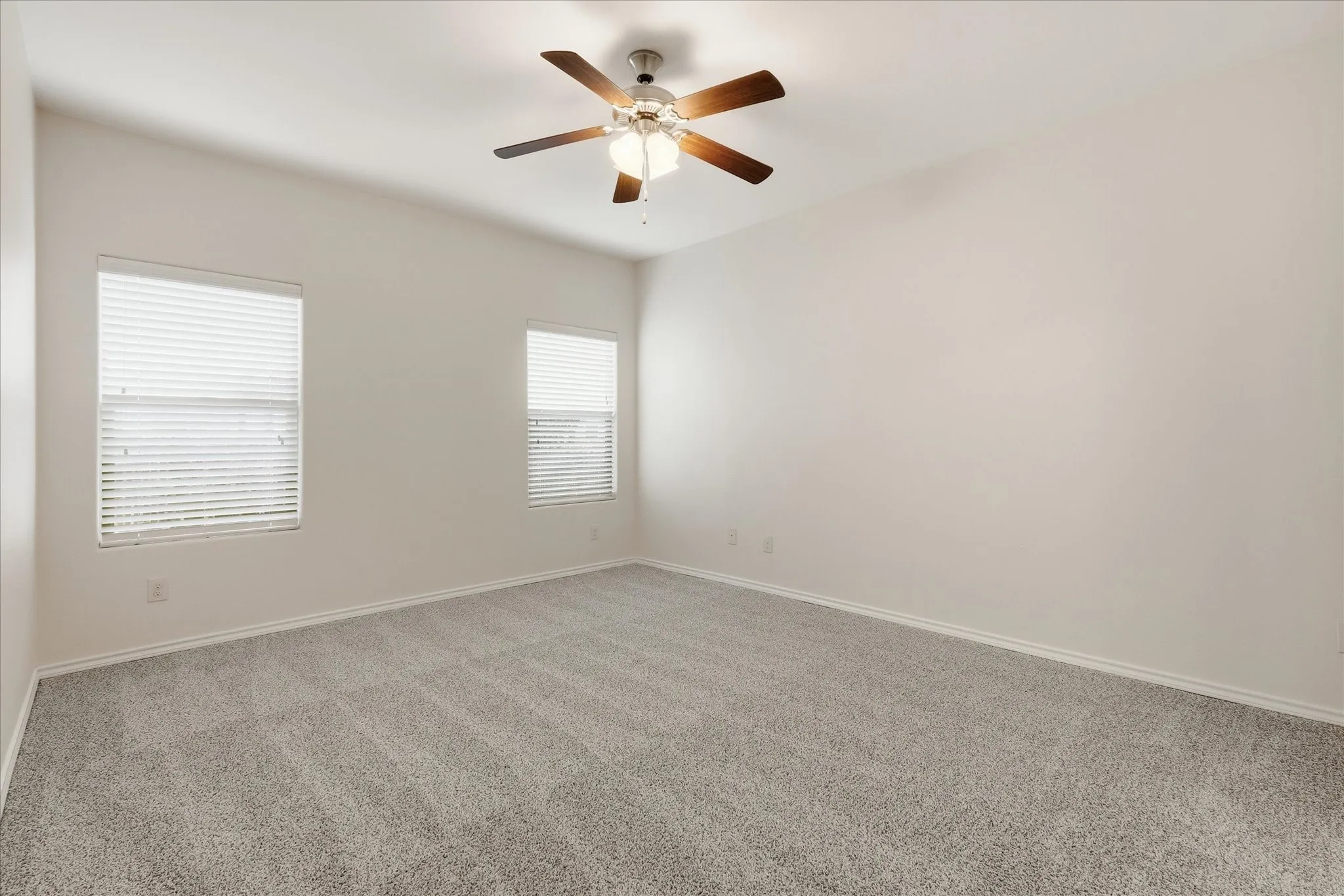 Spacious room featuring vaulted ceilings and a ceiling fan with light fixture