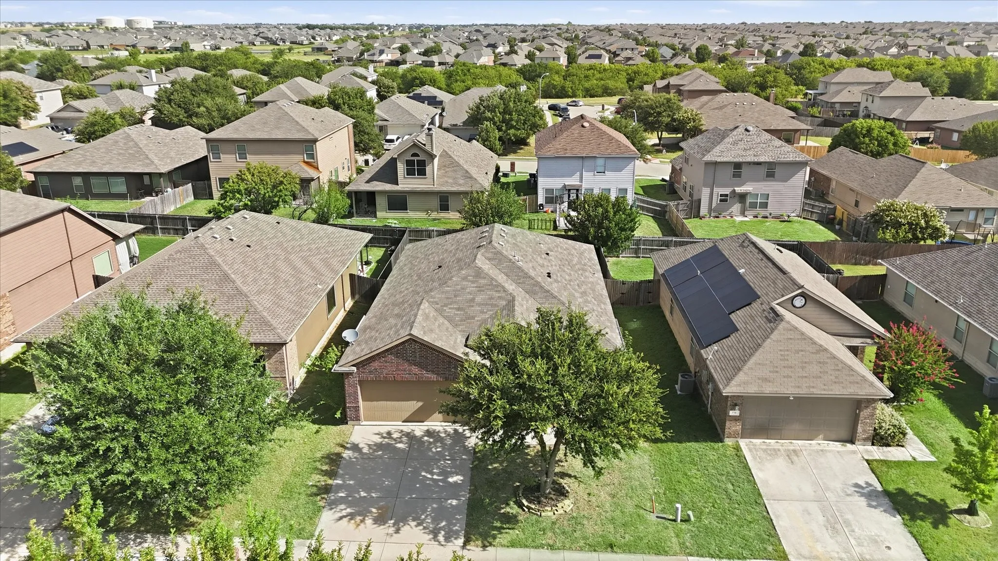Aerial view showcasing residential properties with manicured lawns and mature trees