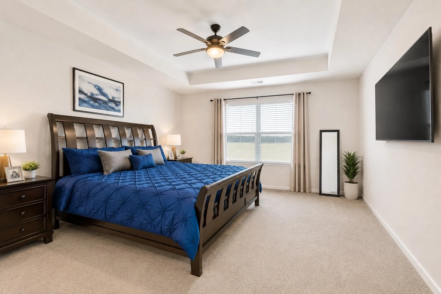 Spacious bedroom featuring a tray ceiling, recessed lighting, and a ceiling fan