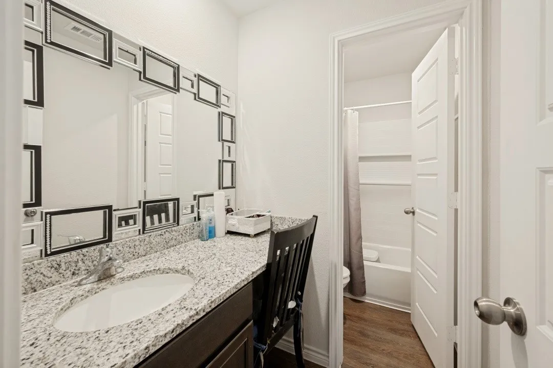 Vanity with a granite countertop and an undermount sink