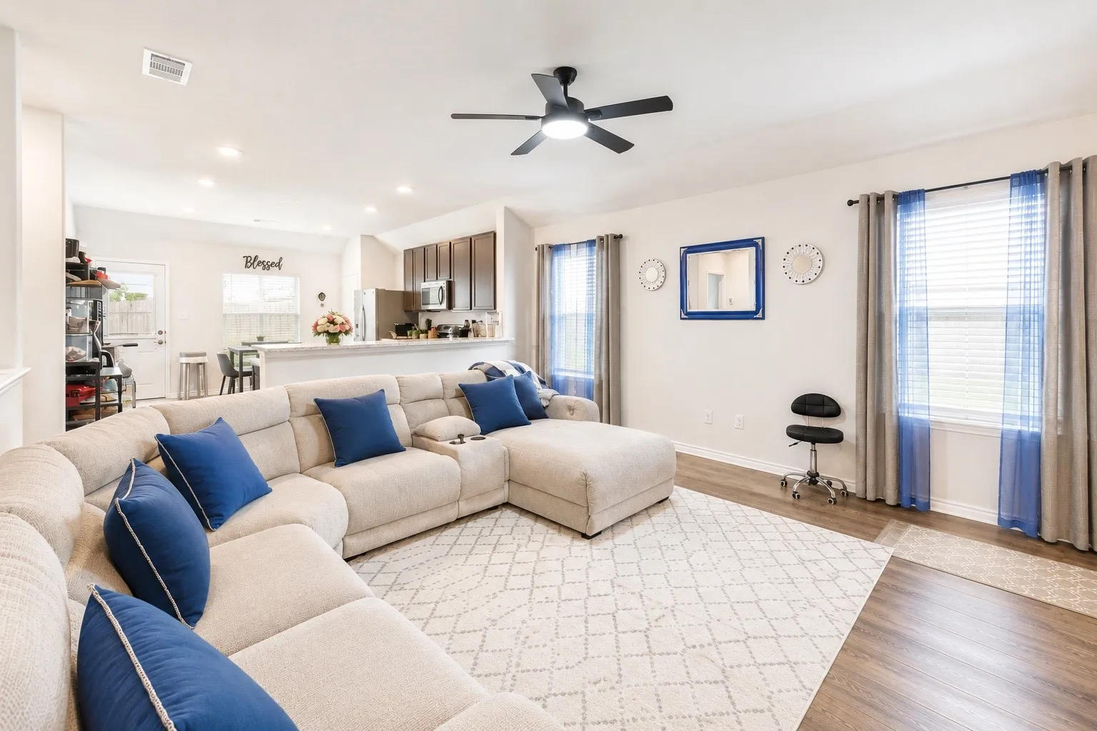 Spacious living area featuring wood-finish flooring, recessed lighting, and a ceiling fan