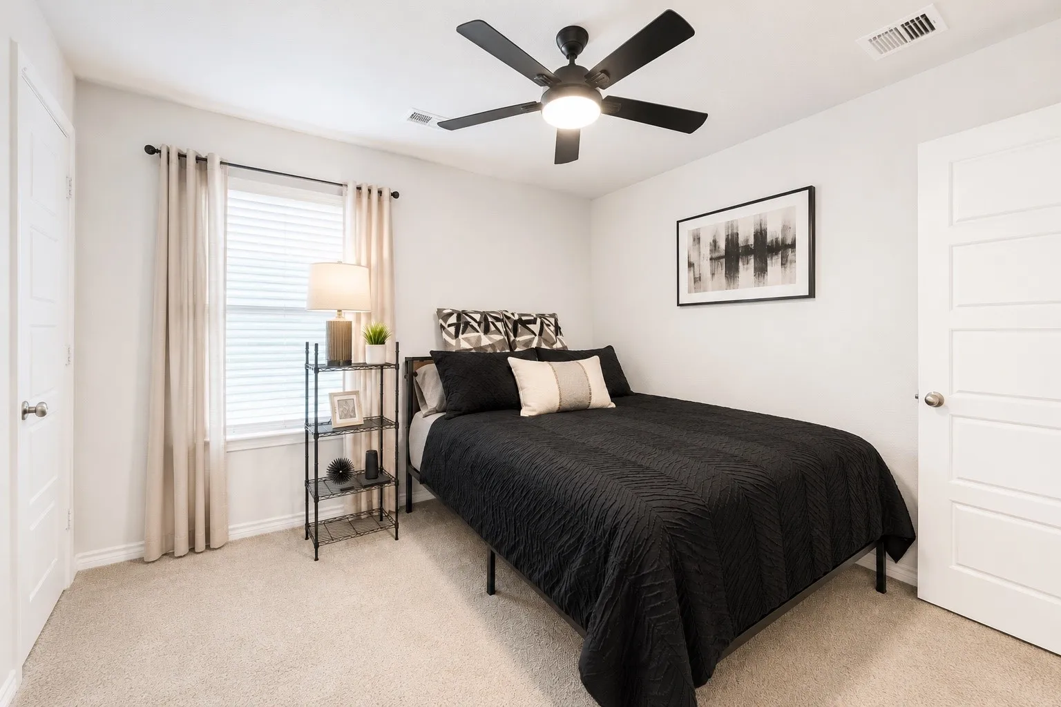 Carpeted room featuring a ceiling fan with light, a window with blinds and curtains, and white paneled doors