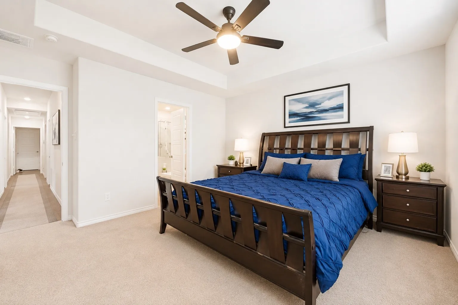 Spacious bedroom with tray ceiling and ceiling fan