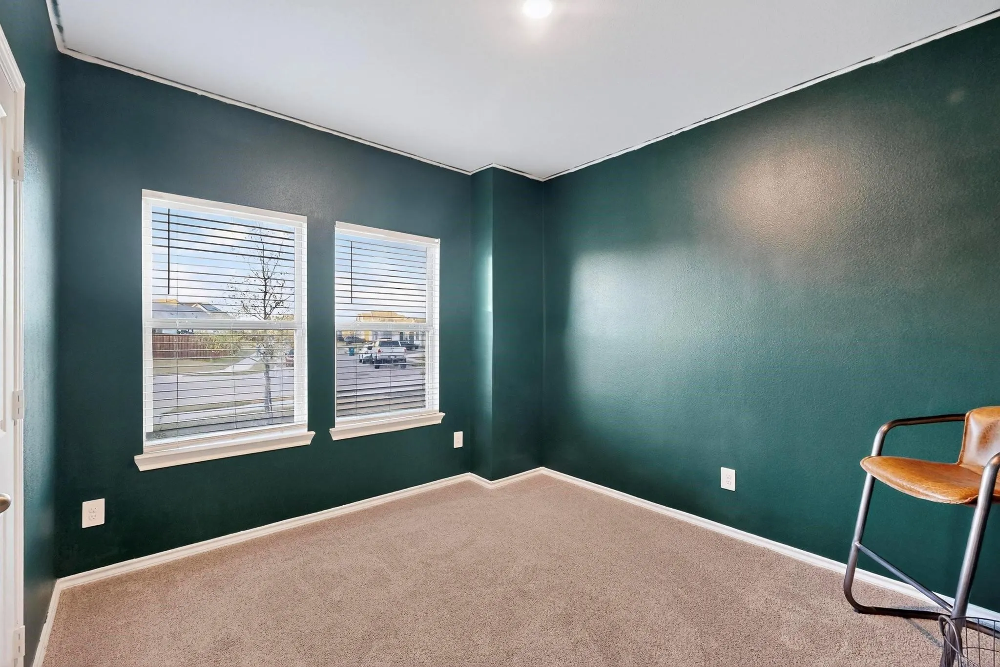 Room featuring bold green walls and neutral carpeting