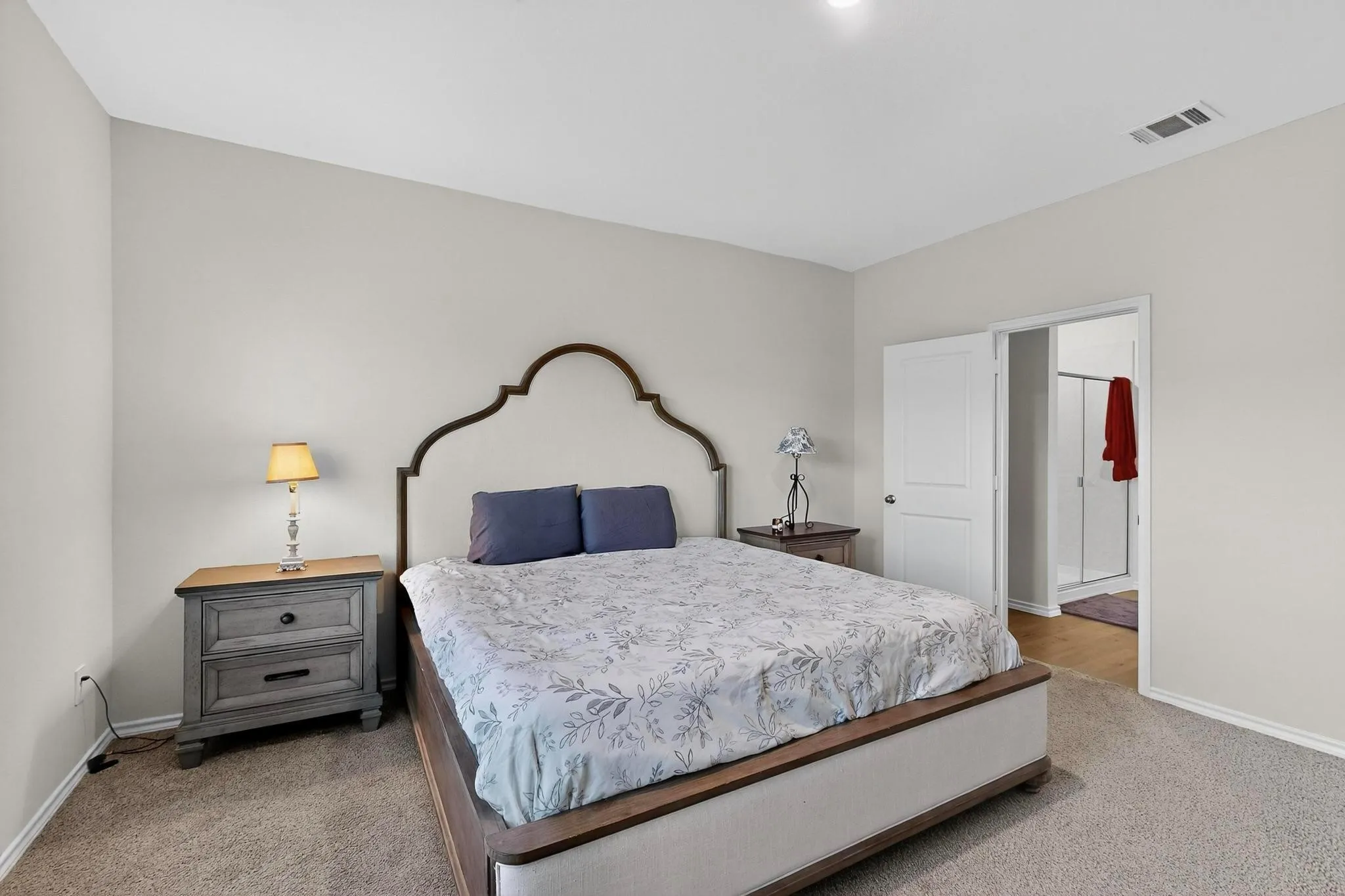 Carpeted bedroom with neutral wall tones and a ceiling-mounted light fixture