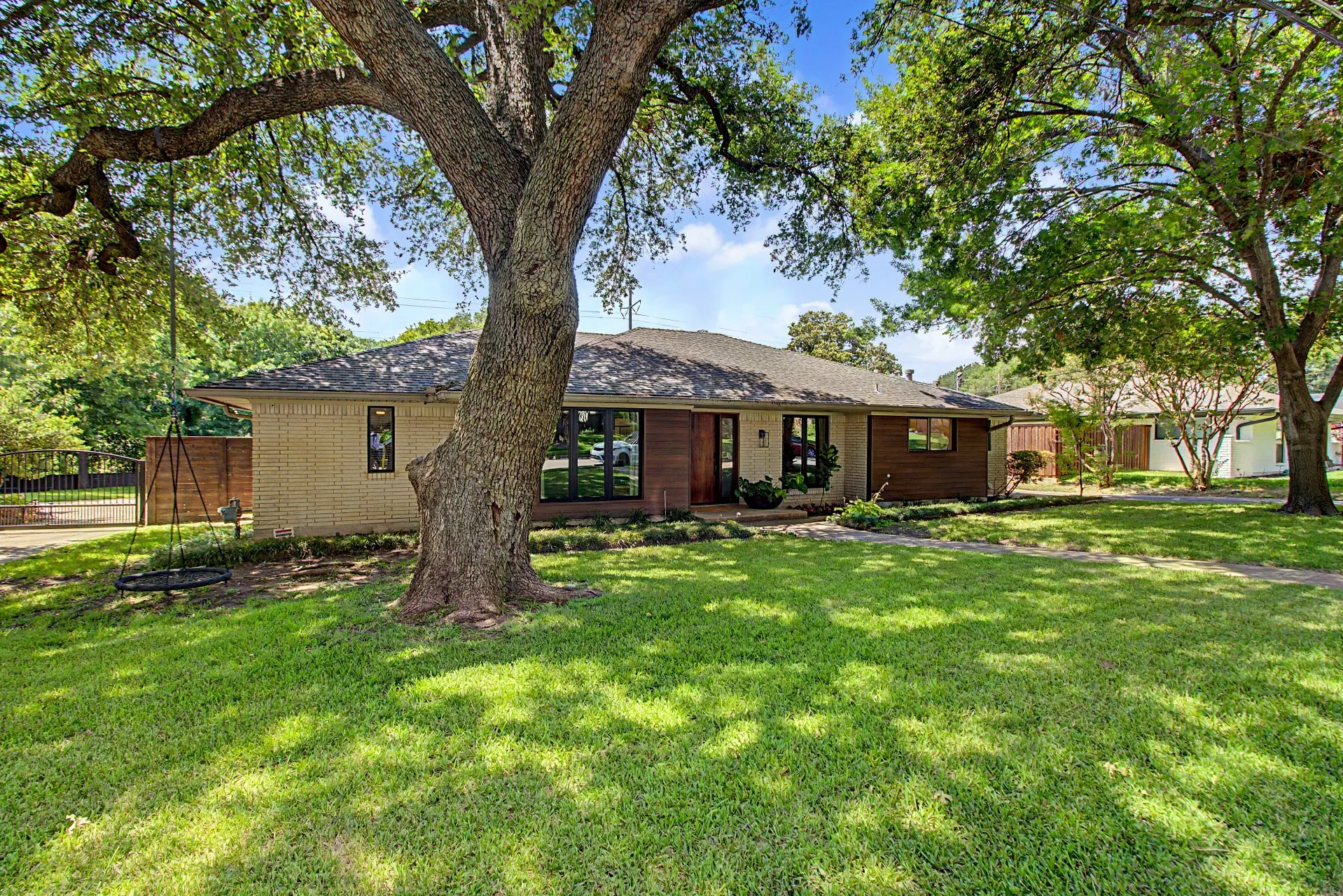 Expansive front lawn with mature trees providing ample shade
