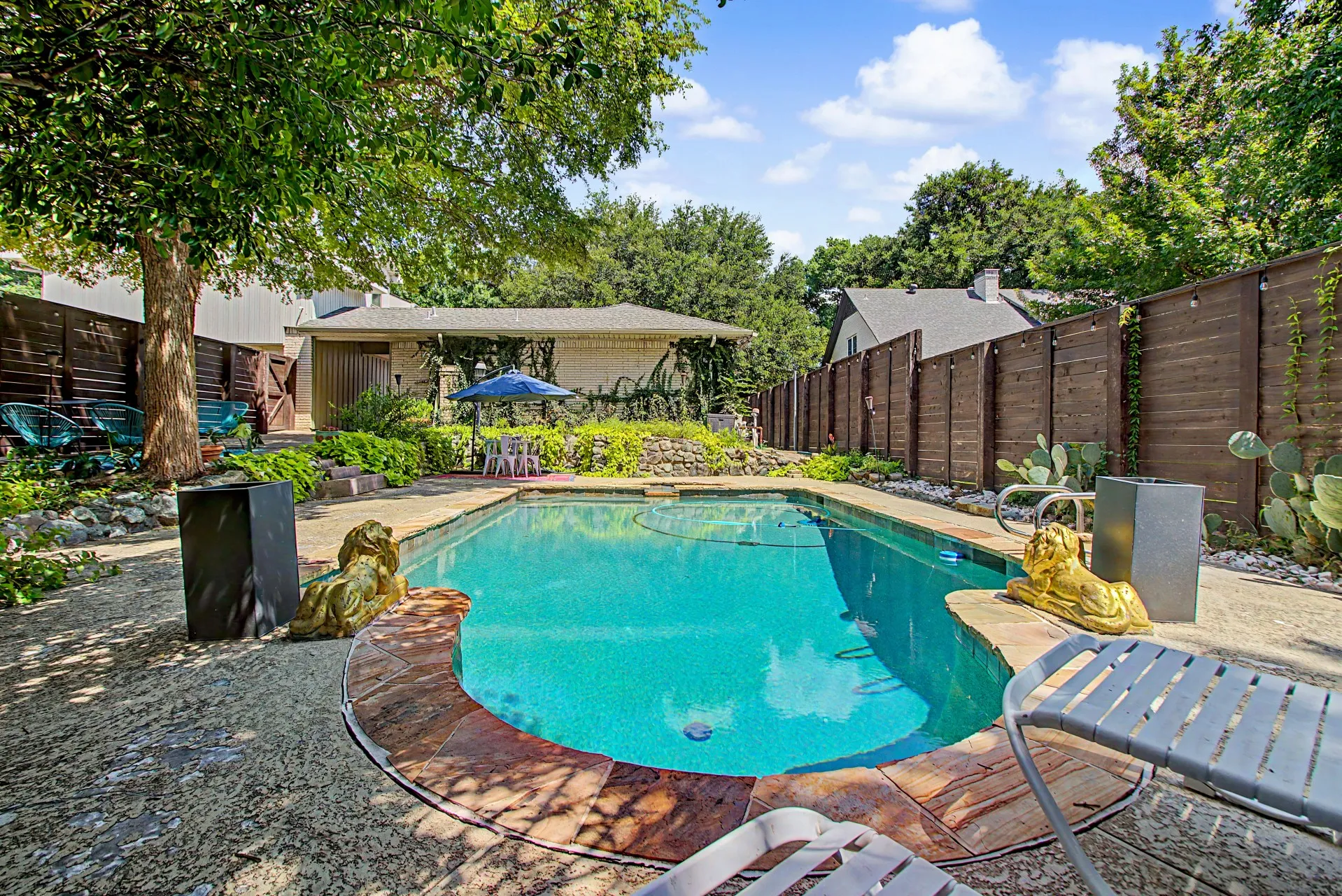 Freeform swimming pool featuring flagstone coping and a surrounding concrete patio