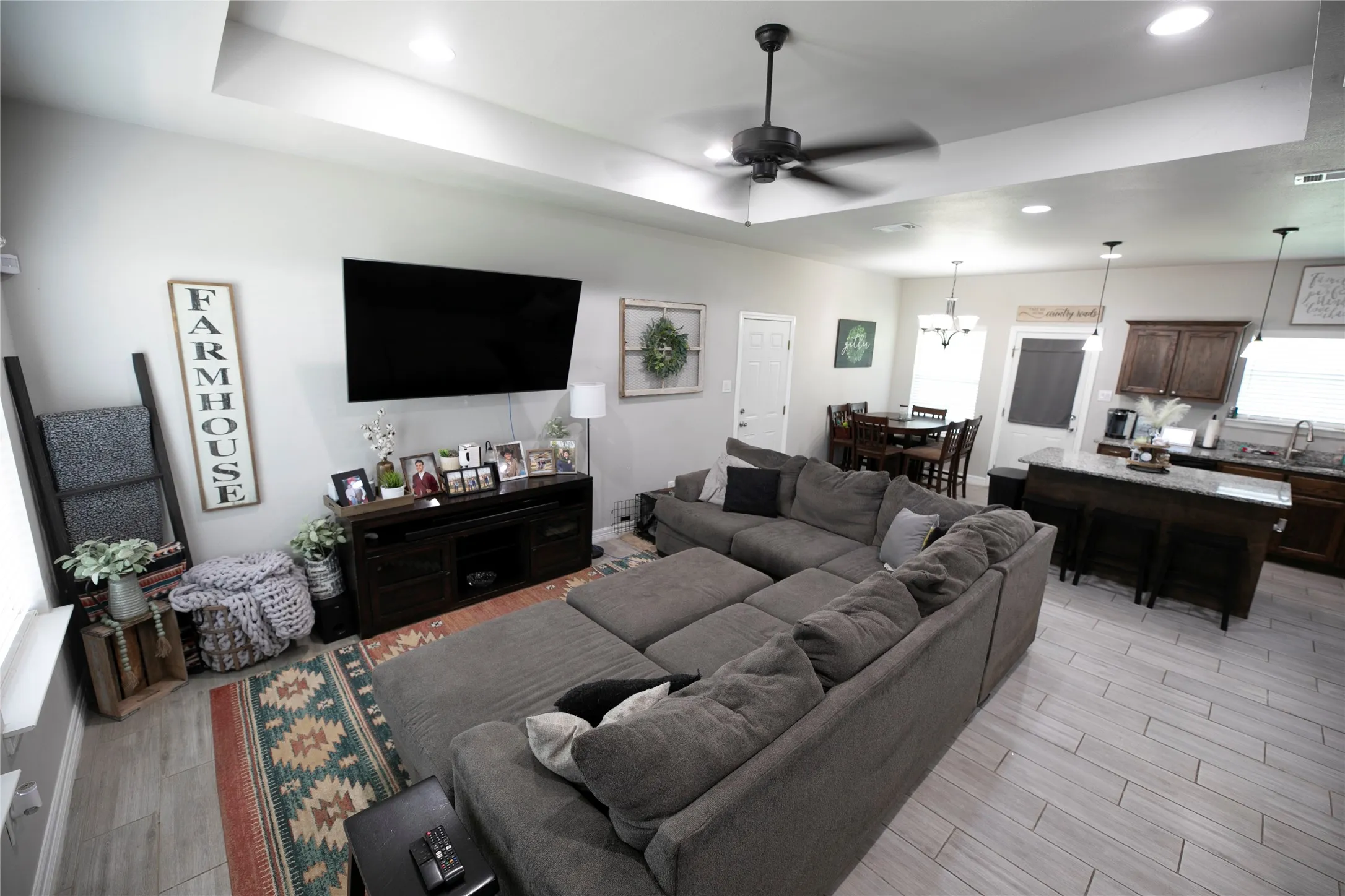 Open-concept living area with tray ceiling and recessed lighting