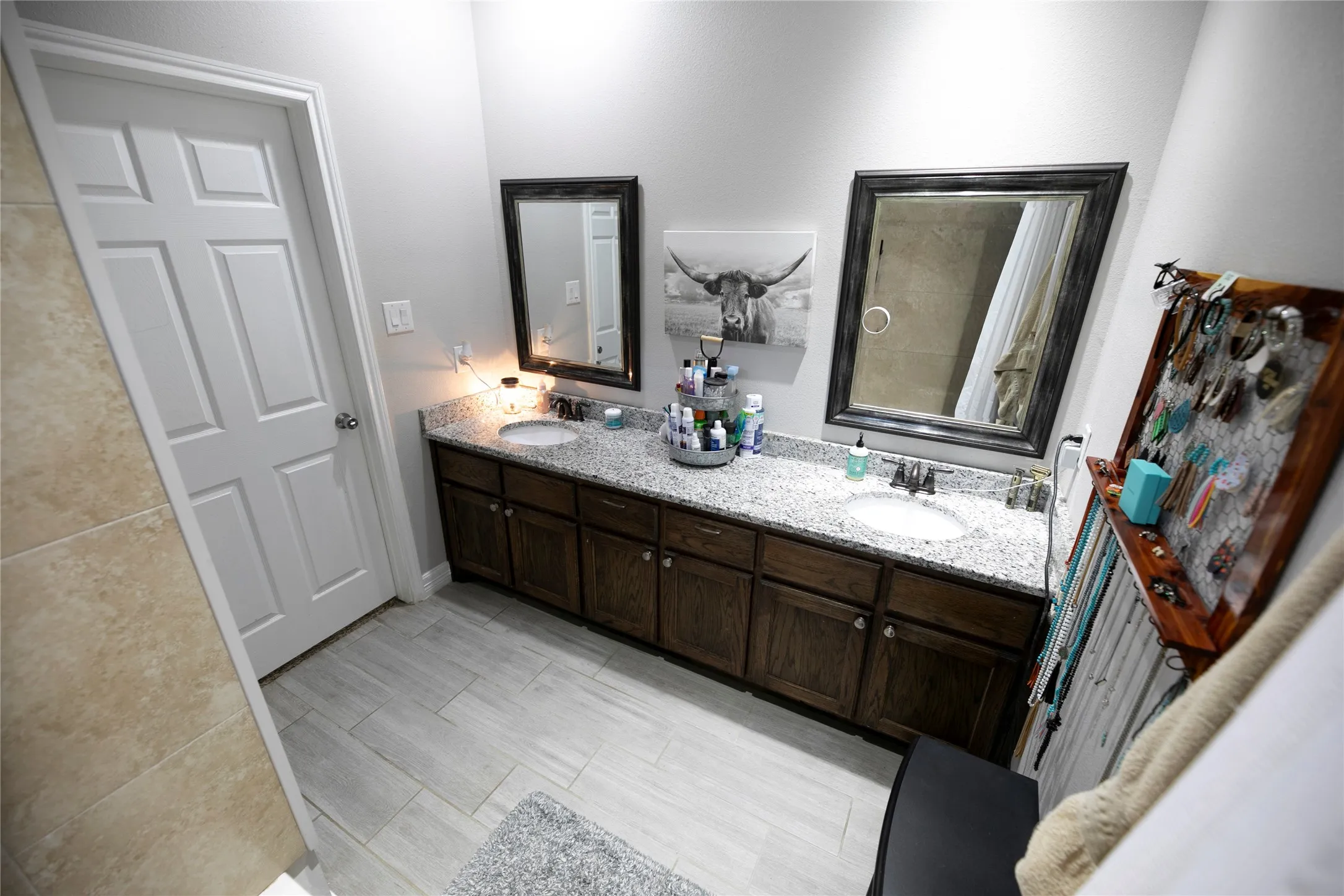 Dual vanity bathroom featuring granite countertops and dark wood-finish cabinetry