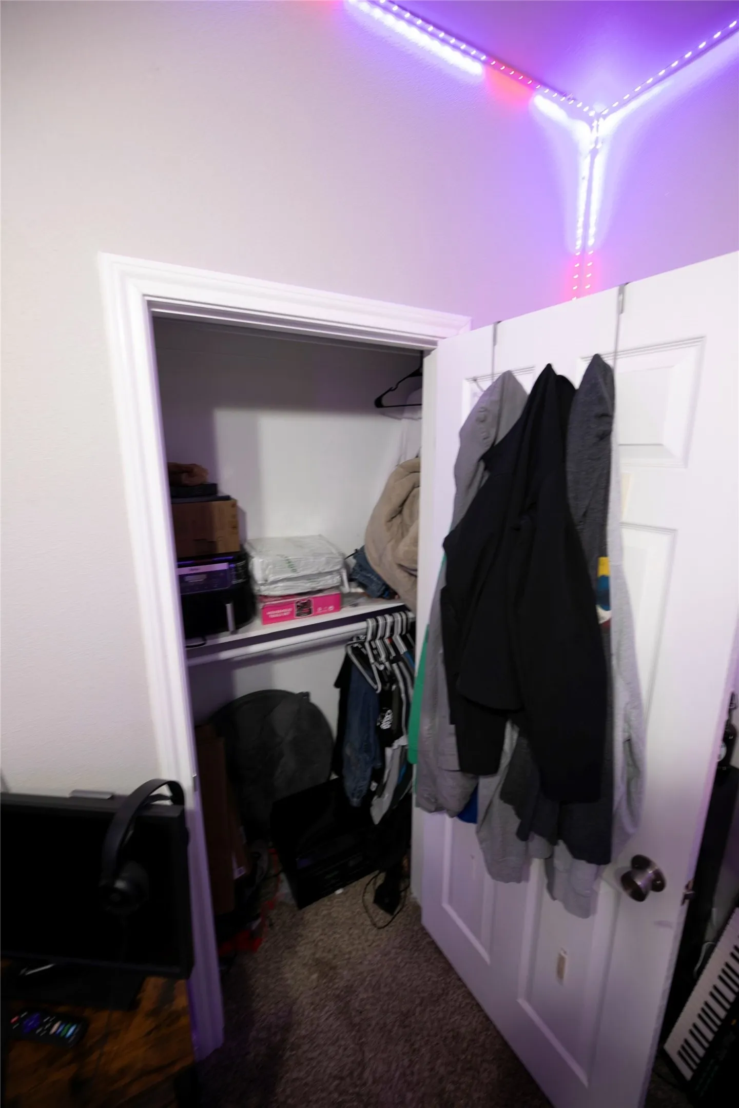 Recessed closet with a multi-level storage system, including a hanging rod and an upper shelf