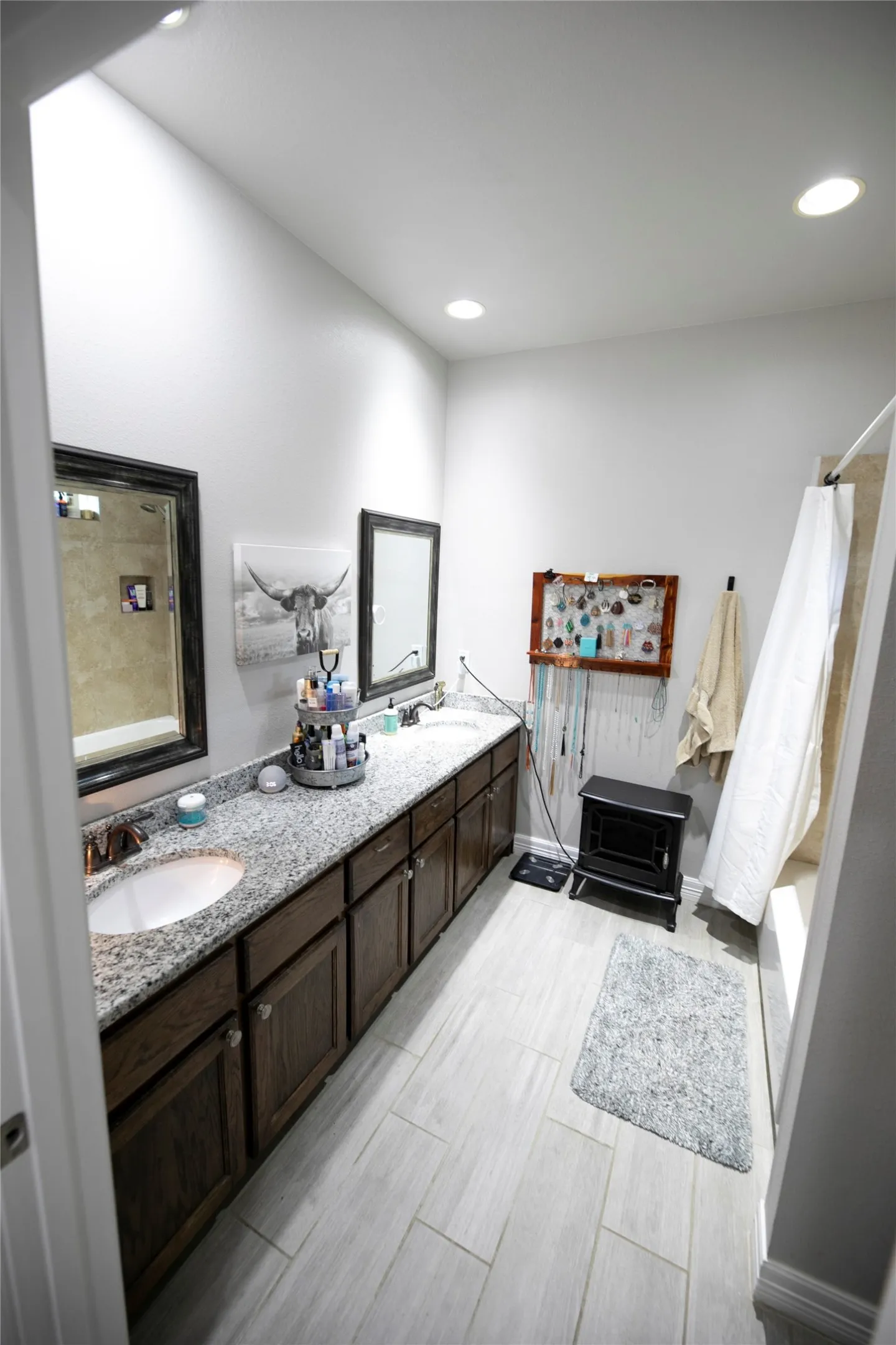 Spacious bathroom featuring a dual vanity with granite countertops and dark wood cabinetry
