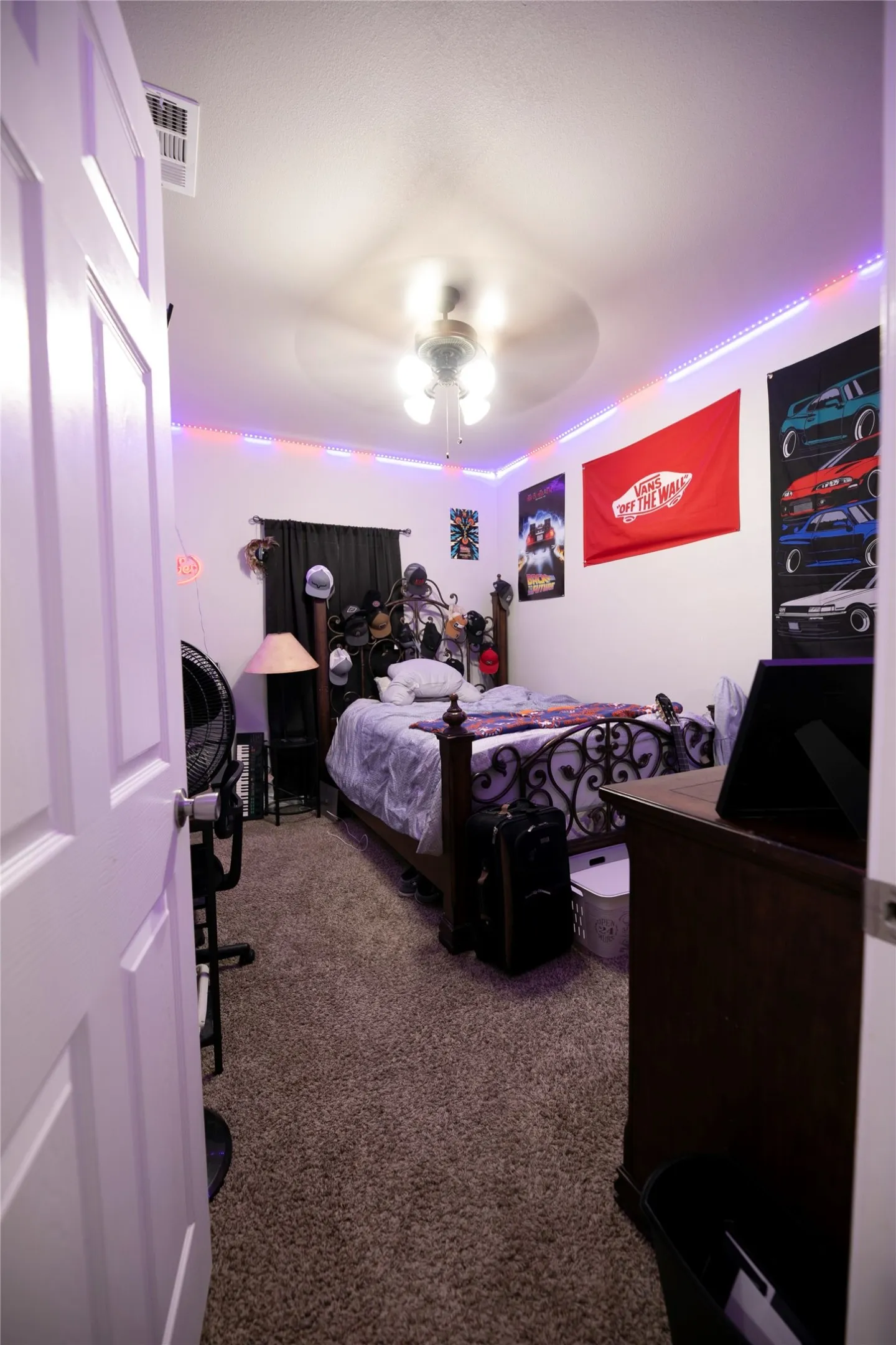 Carpeted interior room featuring a ceiling fan with integrated lighting