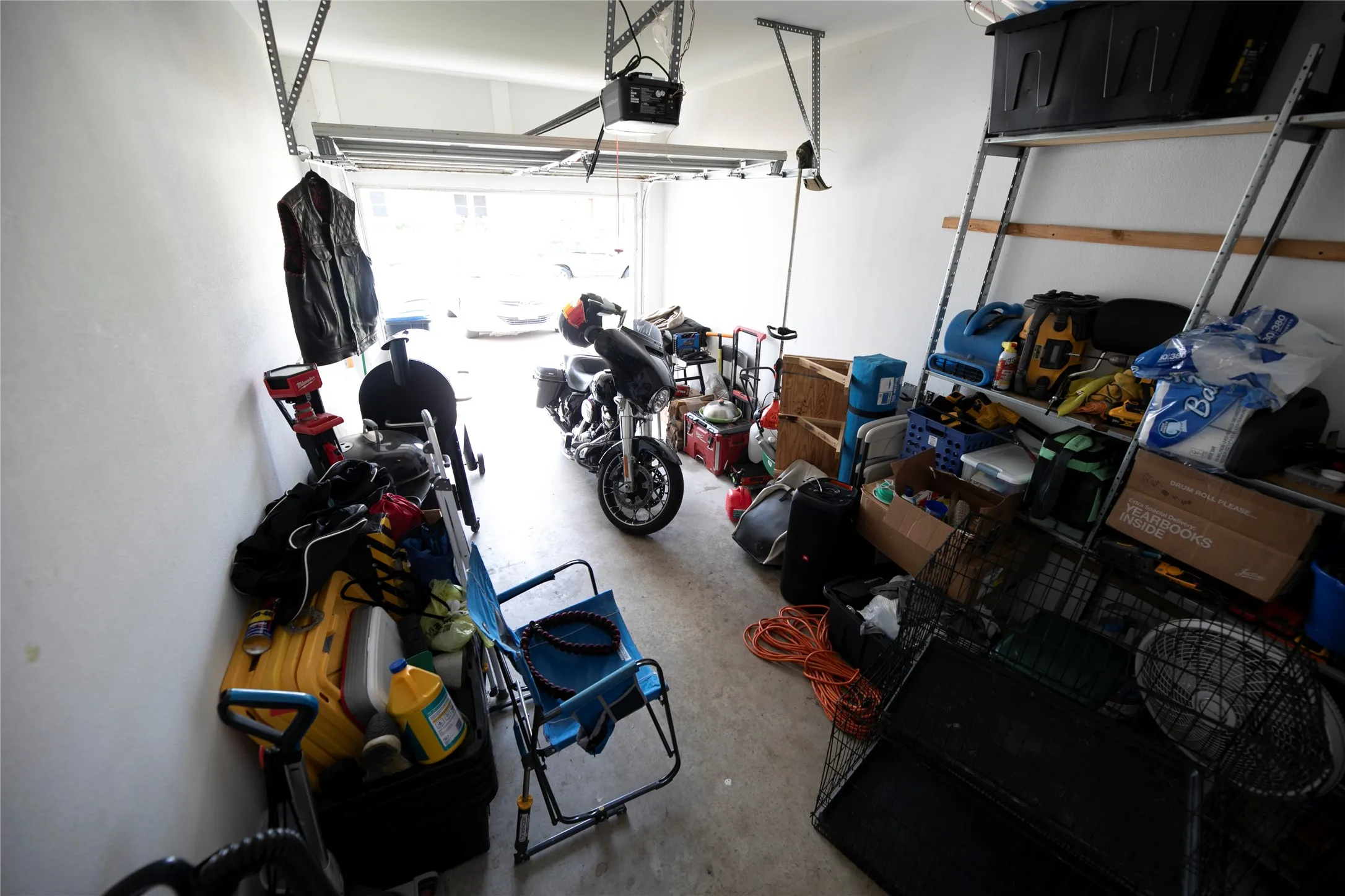 Spacious garage featuring white painted walls, a concrete floor, and an overhead garage door