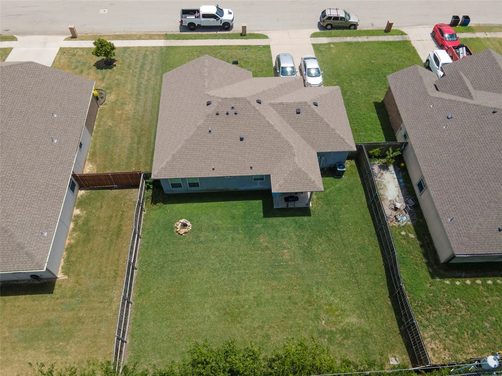 Private backyard featuring a covered patio, a grassy lawn, and a wood privacy fence