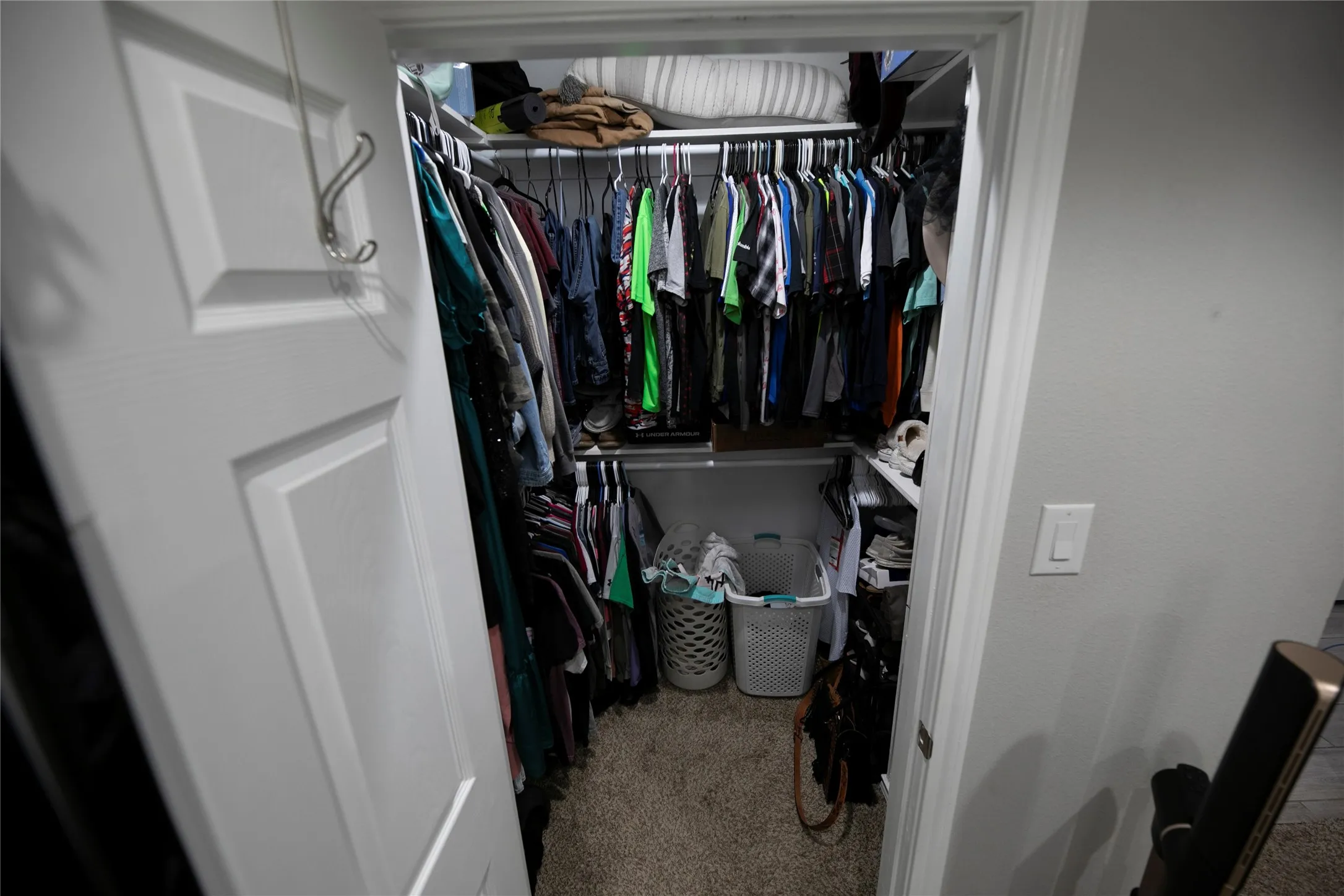 Walk-in closet featuring carpet flooring, built-in shelving, and hanging rods