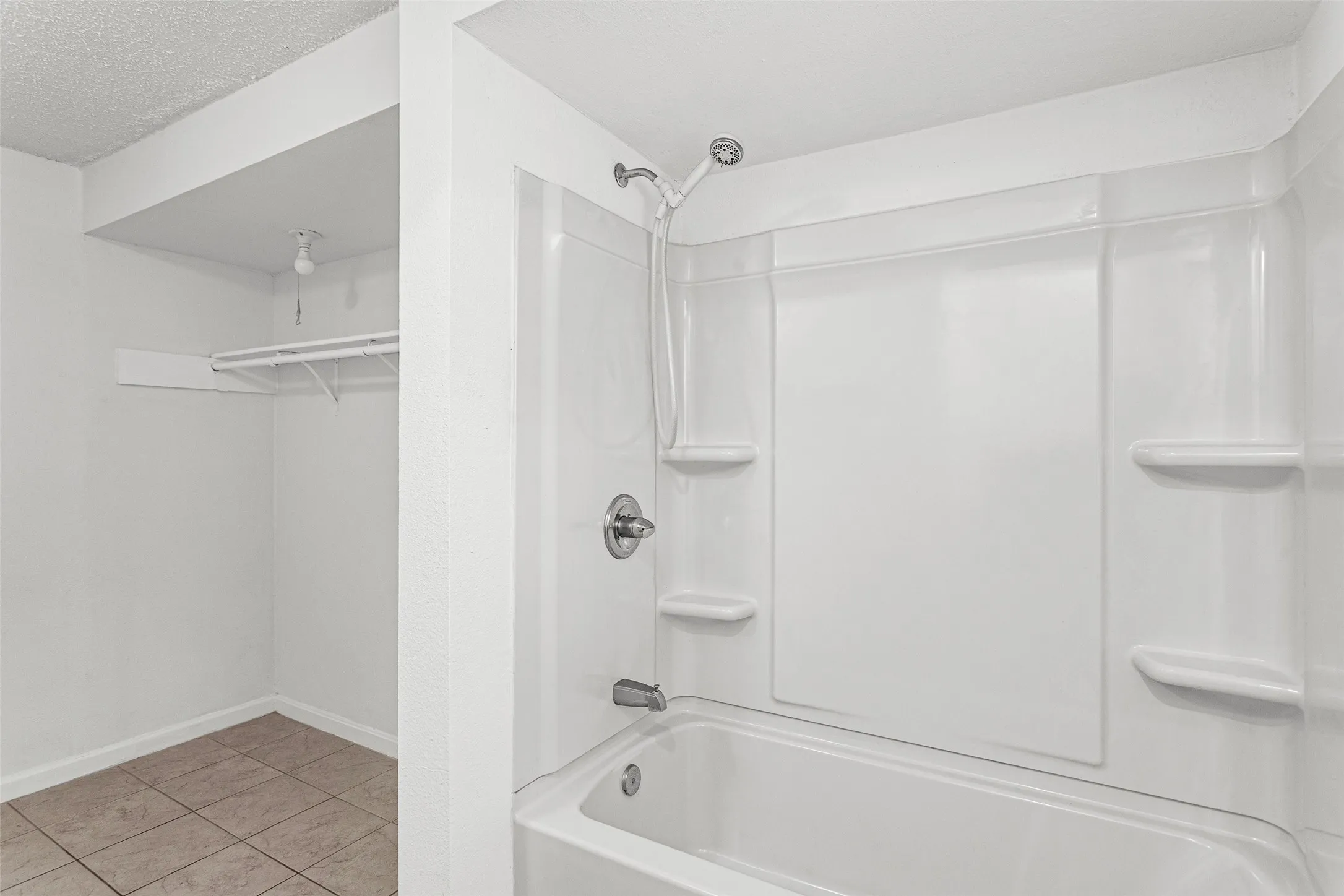 Tub and shower combination with a single-handle fixture and integrated shelving