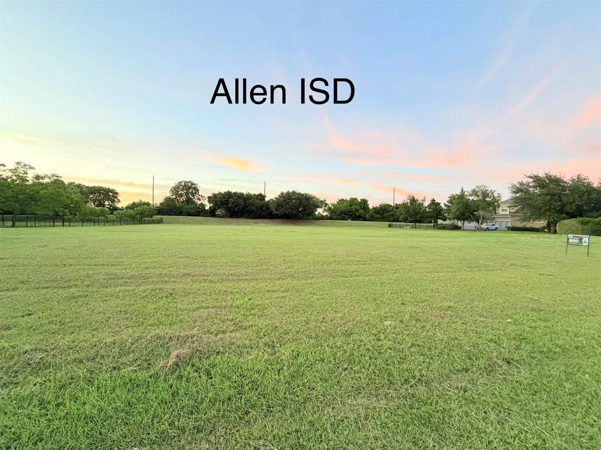 Expansive grassy lot with mature perimeter trees