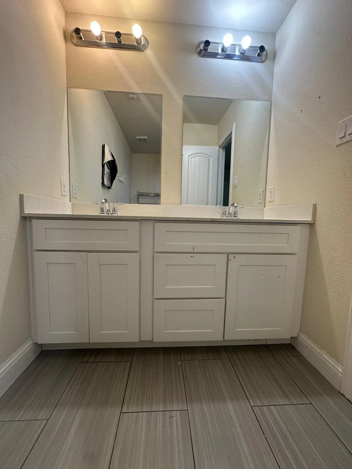 Primary bathroom with Double vanity featuring white shaker-style cabinetry, a light-toned countertop, and dual rectangular sinks