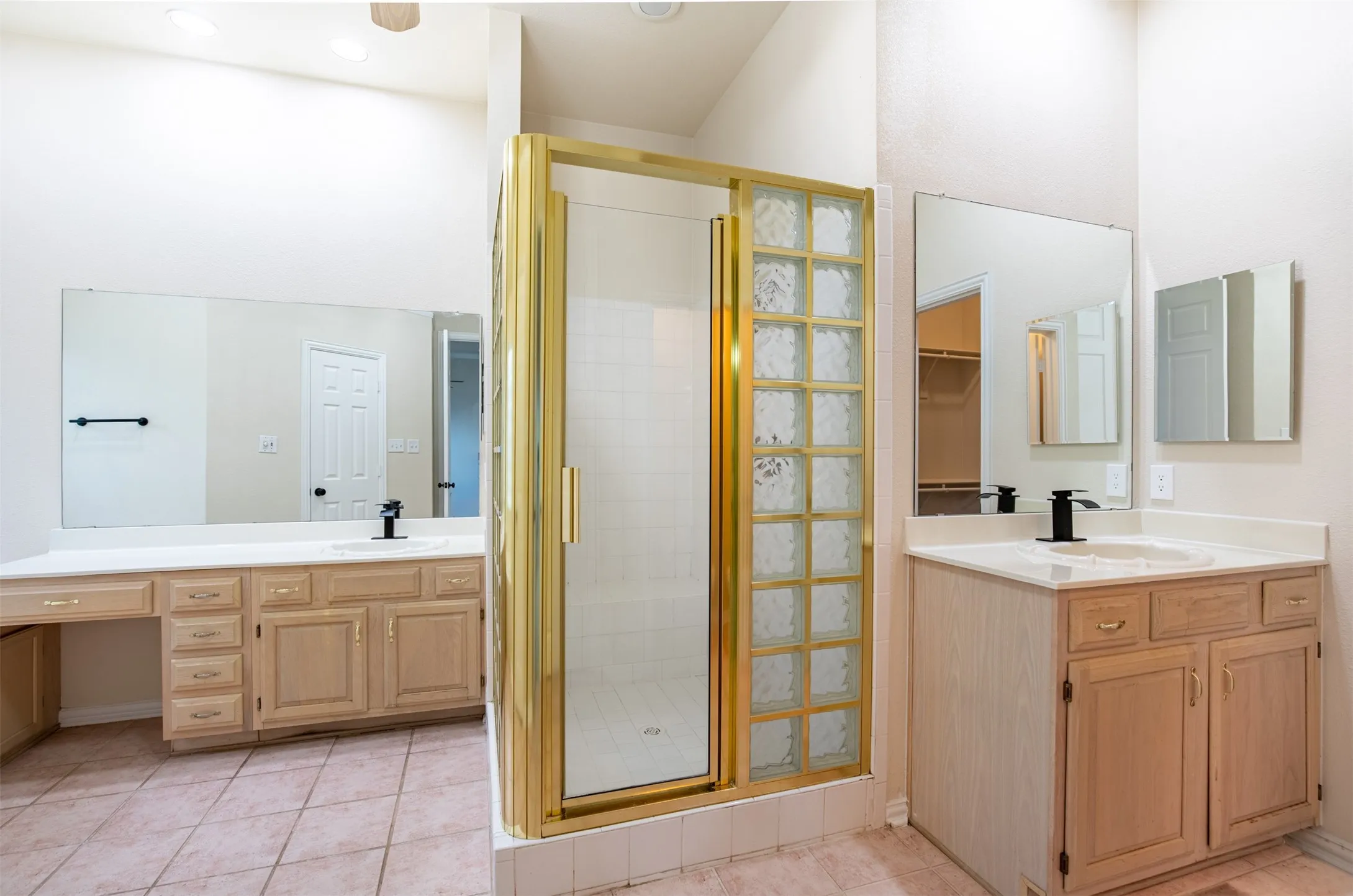 En-suite bath features dual vanities with sitting area, and framed shower.