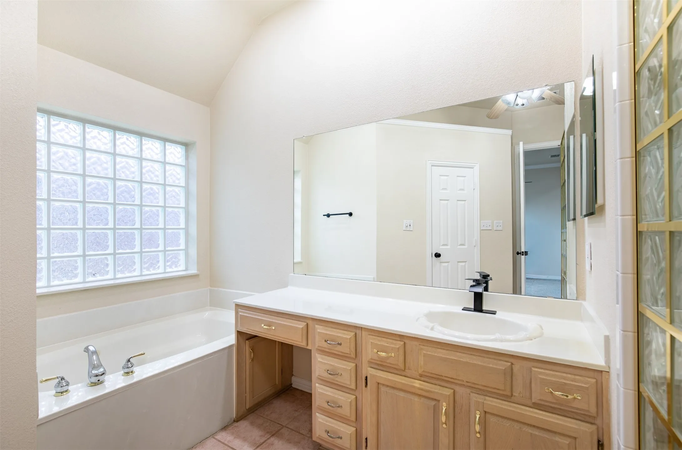 En-suite bath with jetted tub and vanity sitting area.