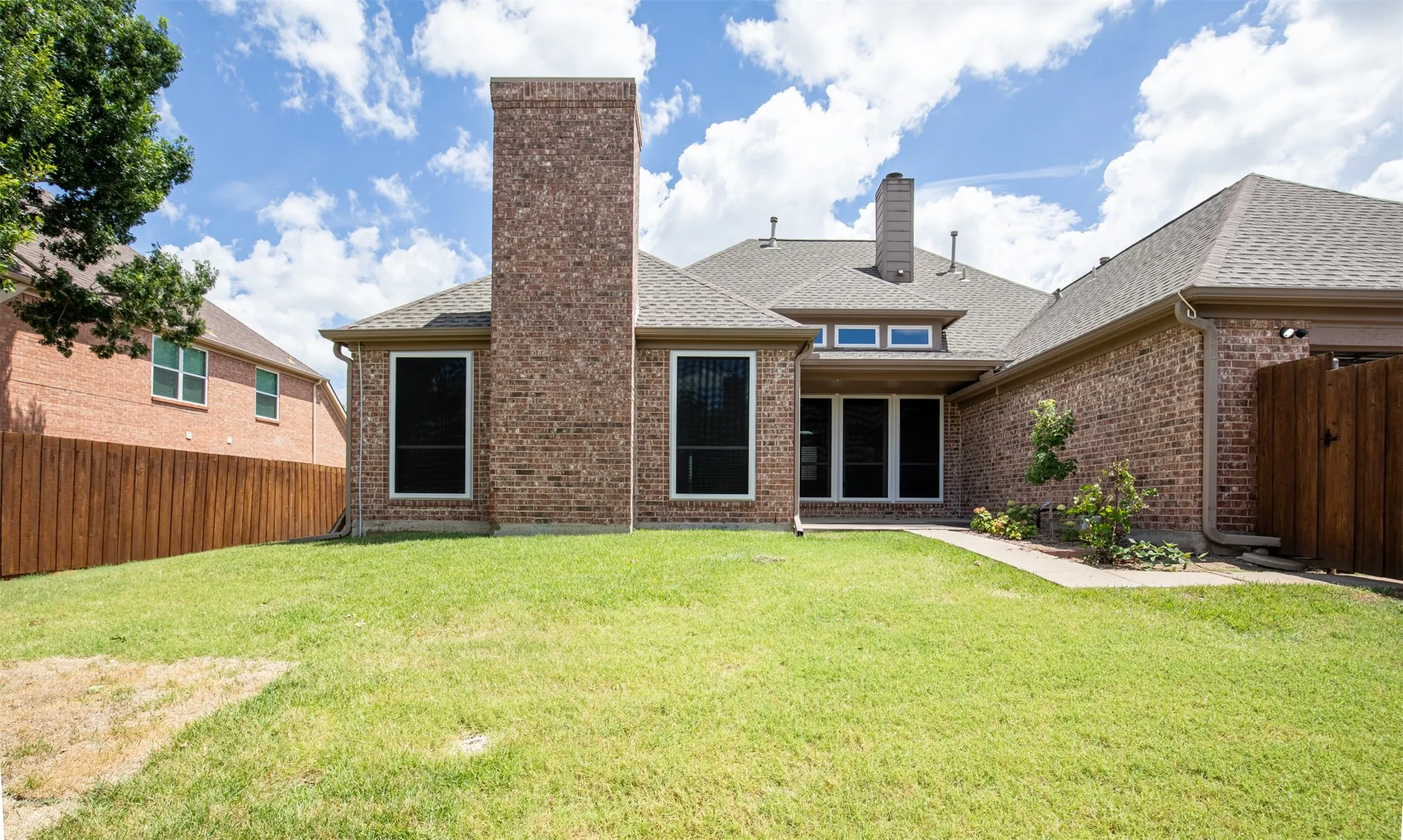 Backyard showcasing grassy yard.