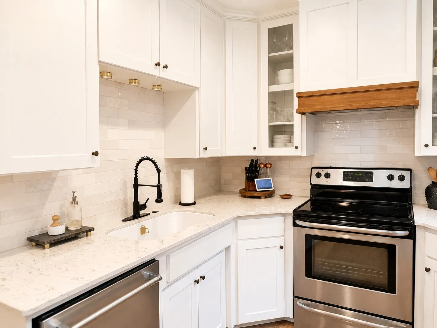 Corner kitchen featuring white shaker cabinetry, light-toned countertops, a stainless steel range, and subway tile backsplash