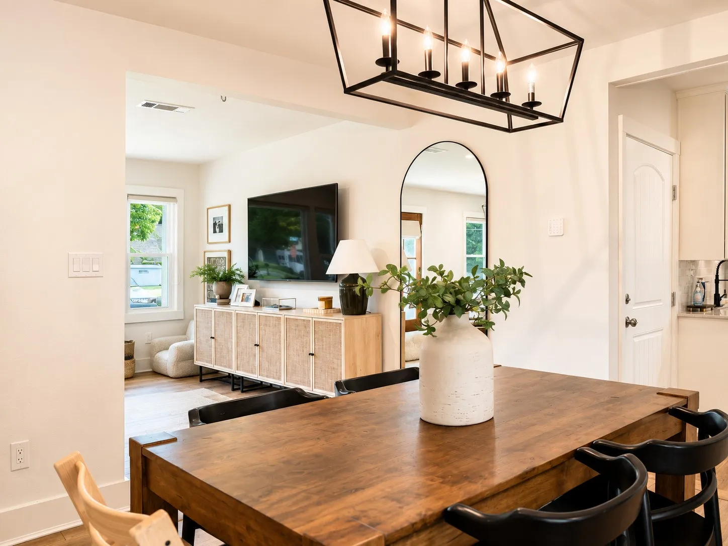 Dining area featuring a wood-finish table with black chairs and a geometric chandelier