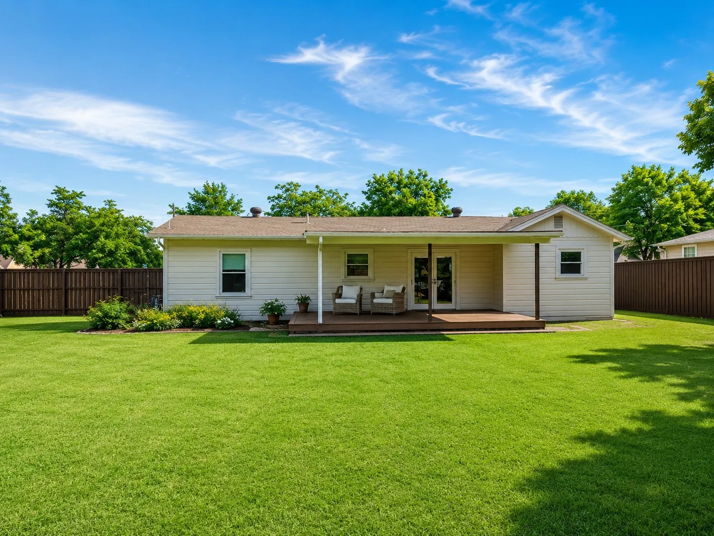 Expansive green lawn with a wood privacy fence