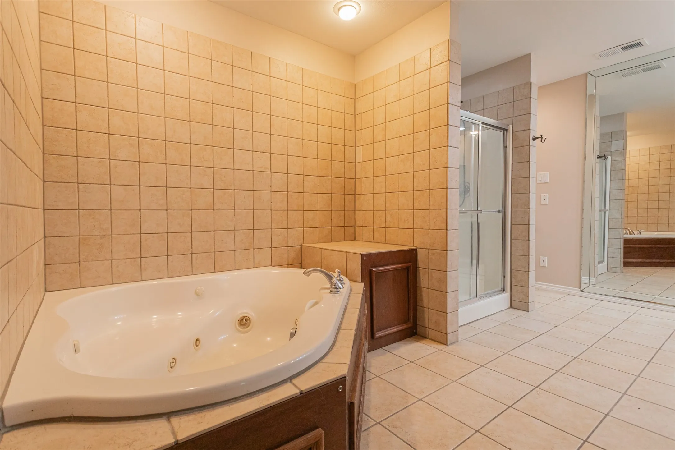 Spa-inspired primary bathroom featuring a soaking tub, separate shower, and spacious layout.