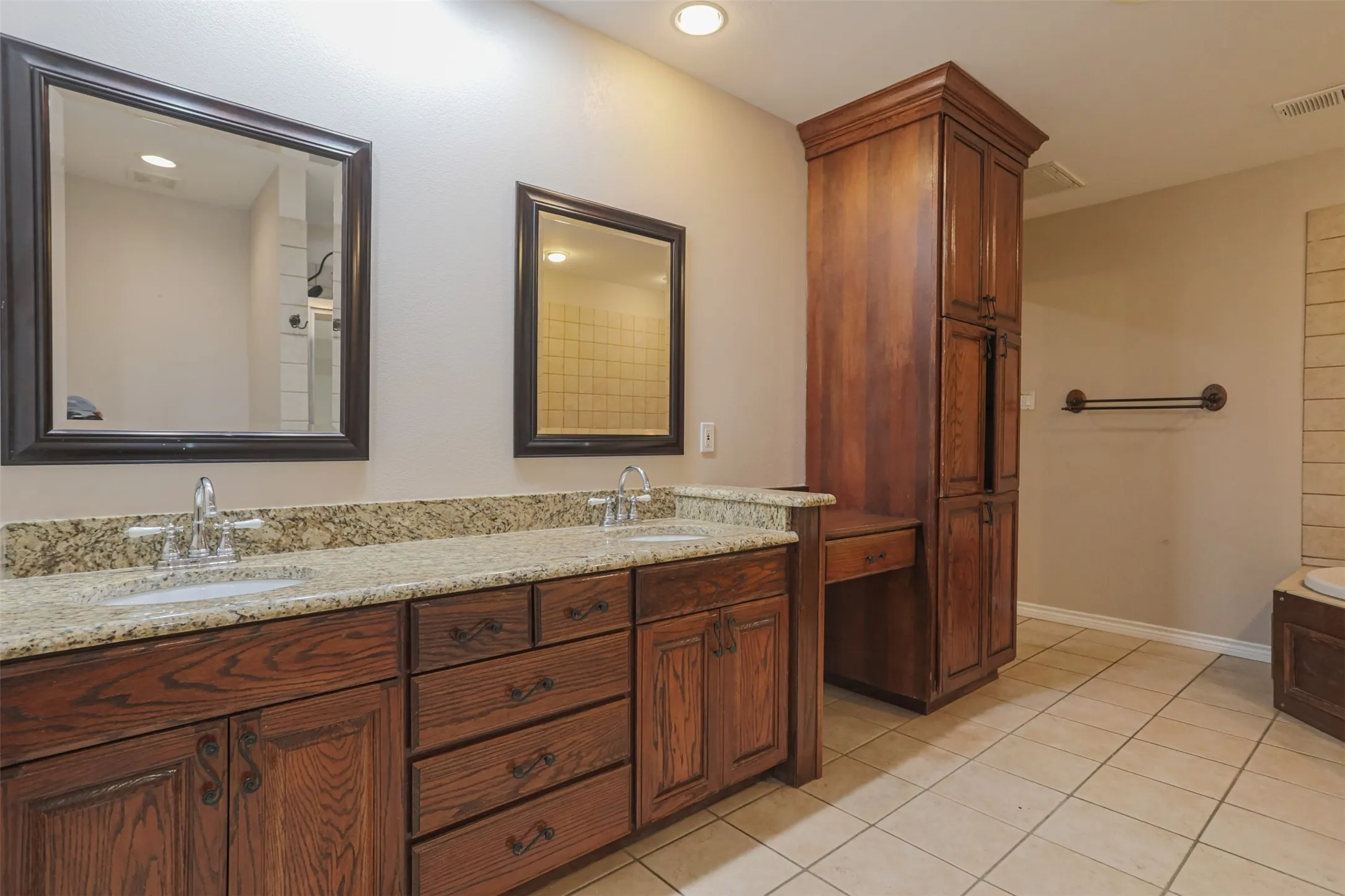 Large primary bathroom with dual vanities, abundant storage