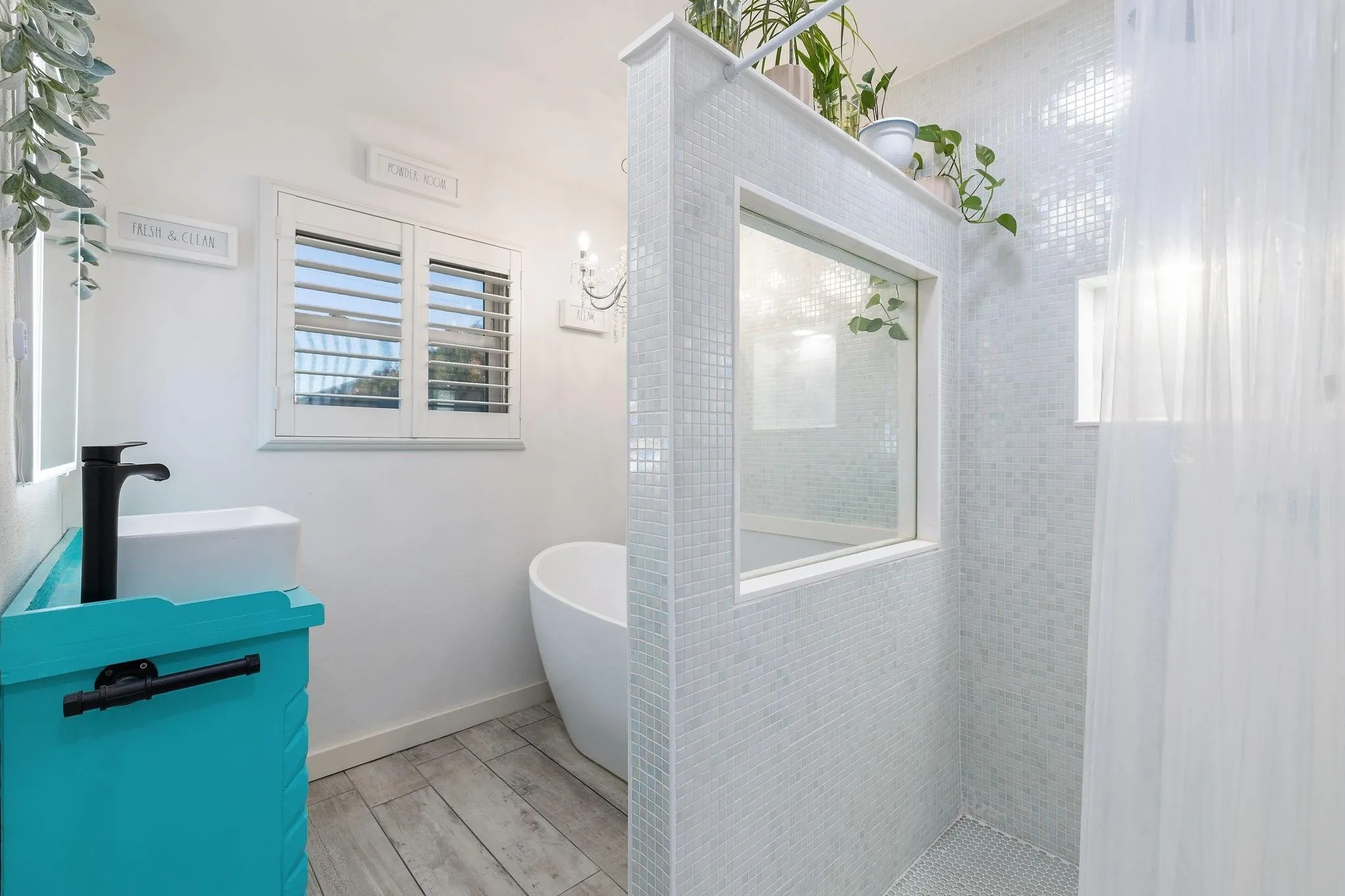 Shower enclosure featuring light-toned square mosaic tiling and a privacy window