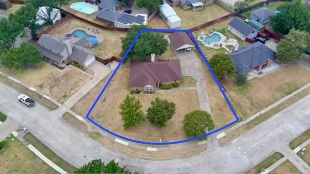 Corner lot (.34 acres) with a single-story residence, carport, and mature trees