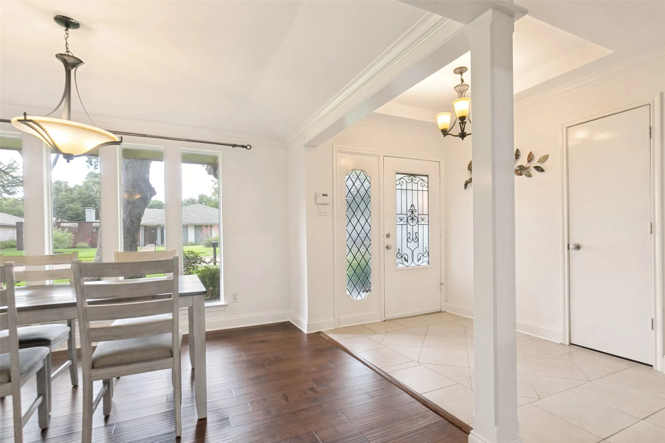 Entryway featuring a decorative glass door, tile flooring, and an overhead chandelier