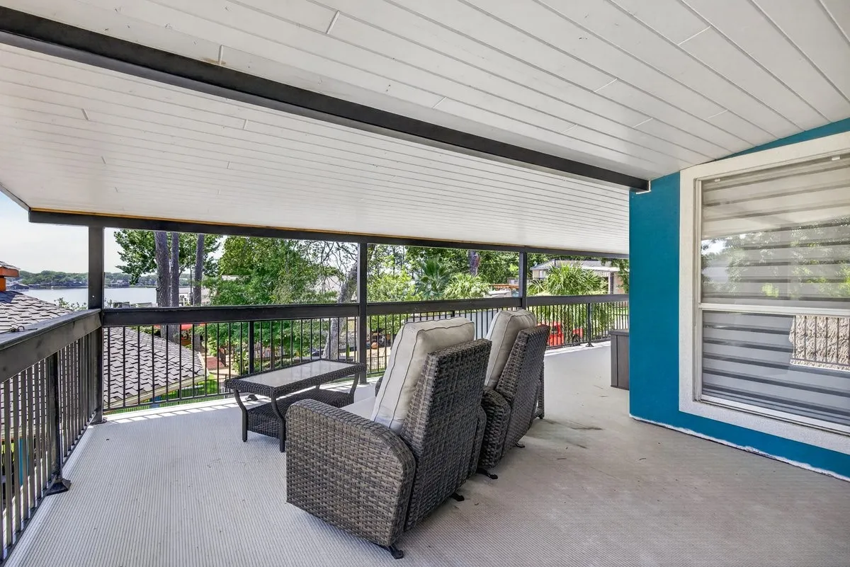 This covered balcony patio space is off of the upstairs primary suite.