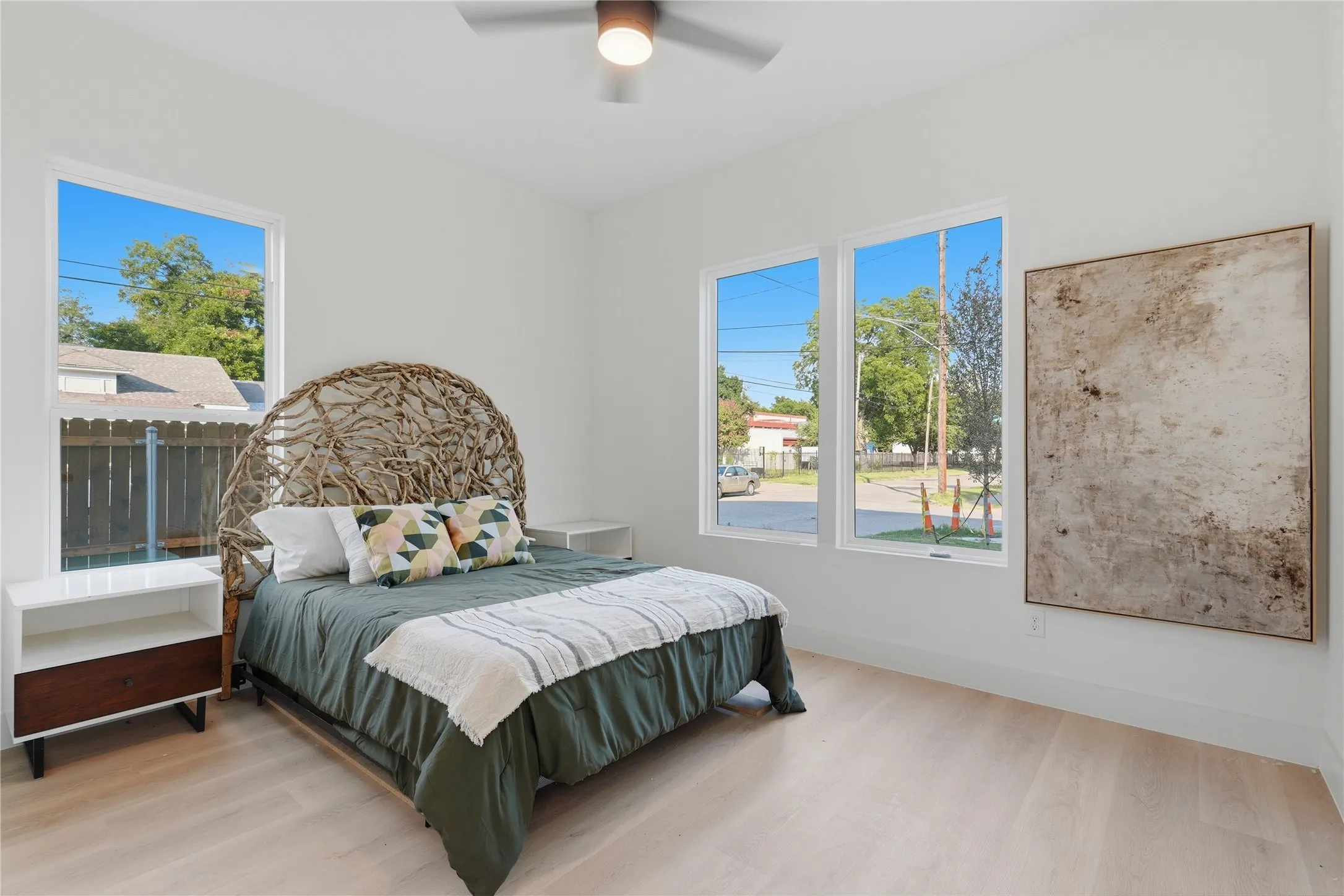 Bedroom featuring light wood-finish flooring, white walls, and a ceiling fan