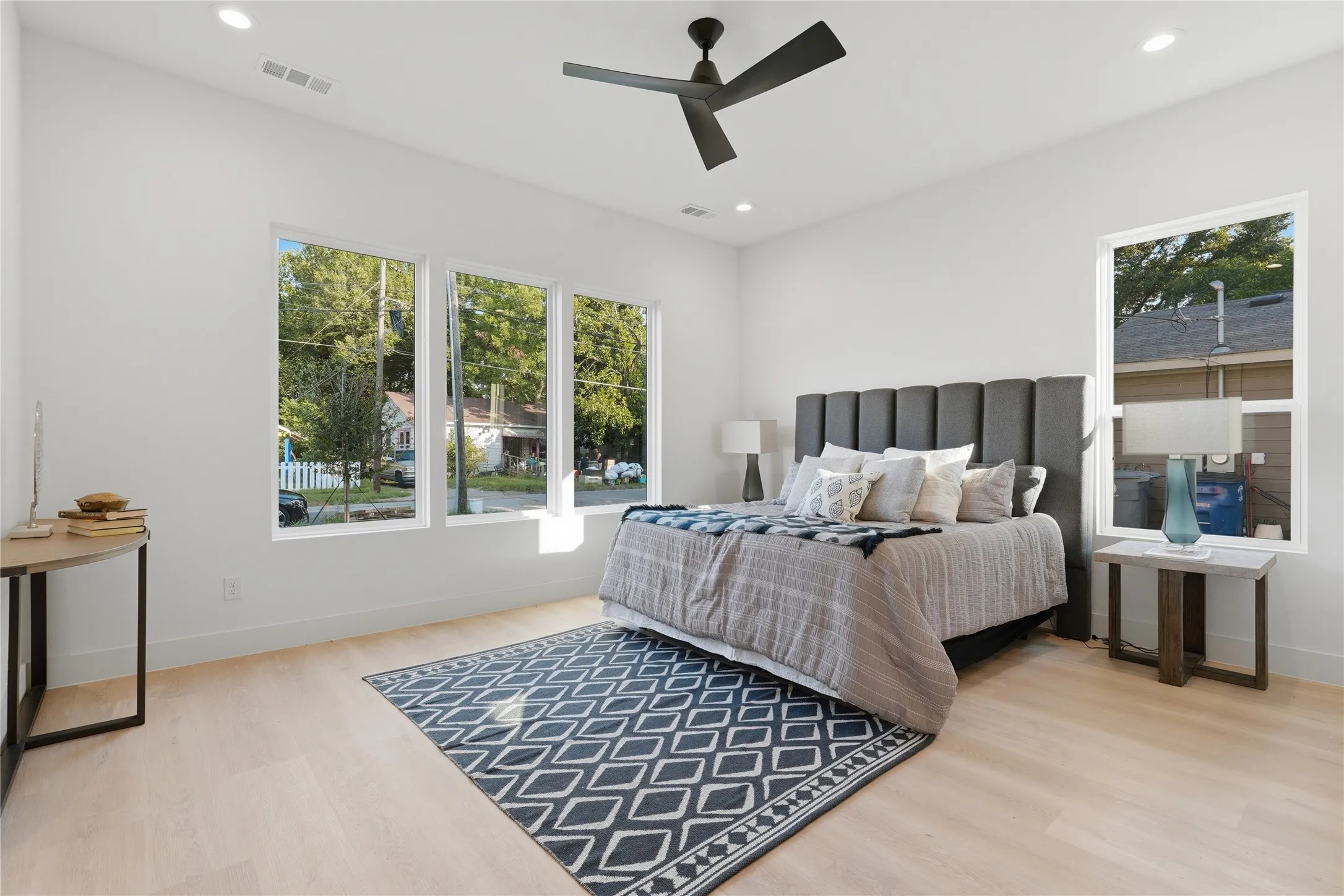 Bright room featuring light wood-finish flooring, white walls, and recessed lighting