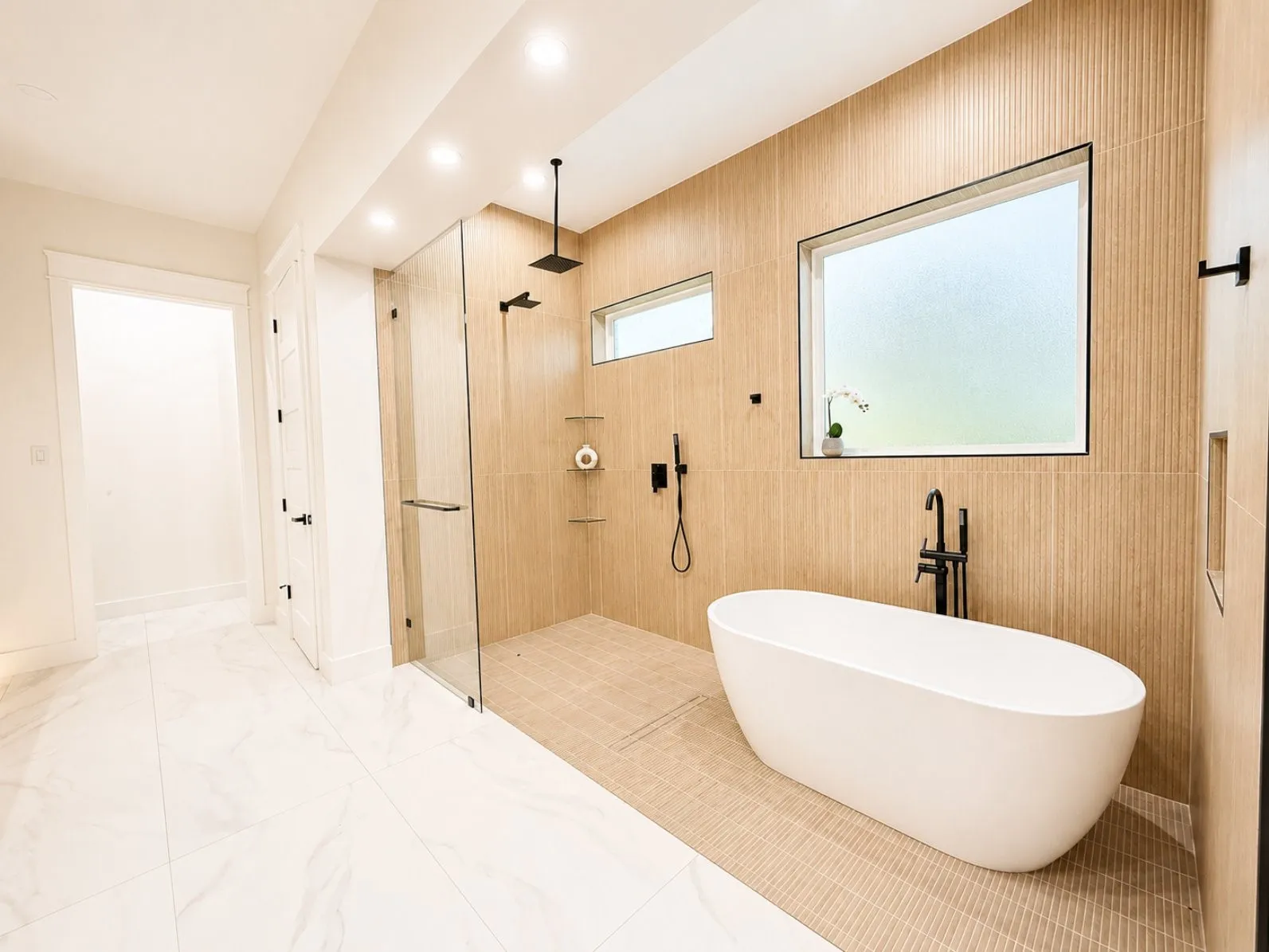 Spacious bathroom with a freestanding soaking tub, a walk-in shower featuring a rain showerhead, and matte black fixtures