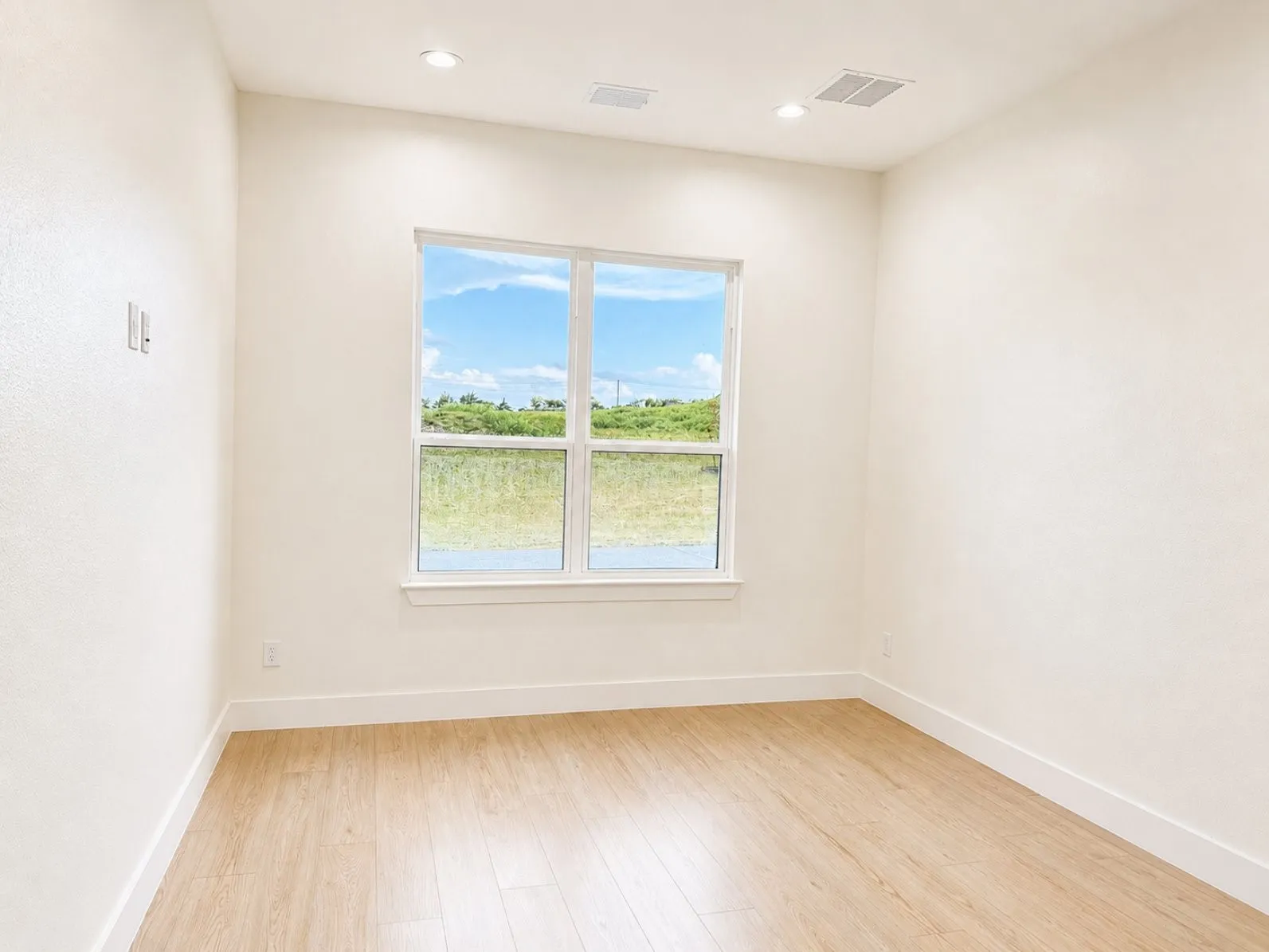 Office room featuring a multi-pane window, wood-finish flooring, recessed lighting, and white baseboards