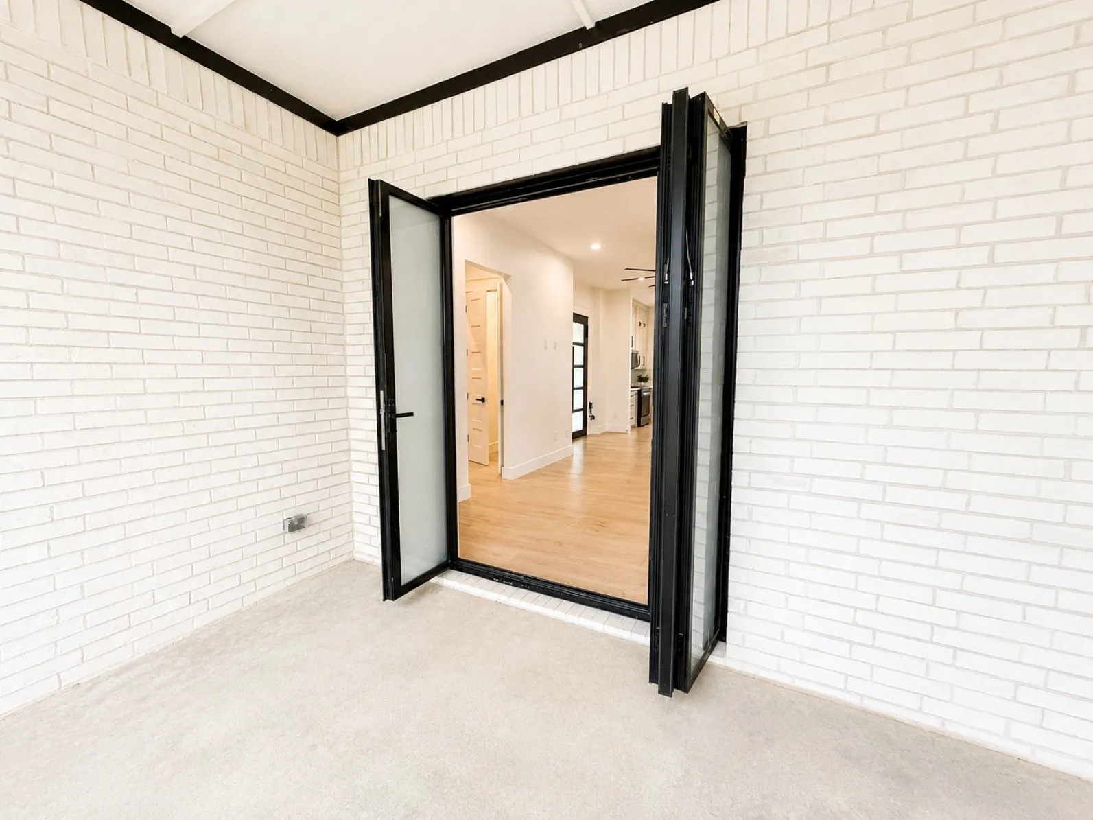 Outdoor area with white brick walls and foldable smart glass door
