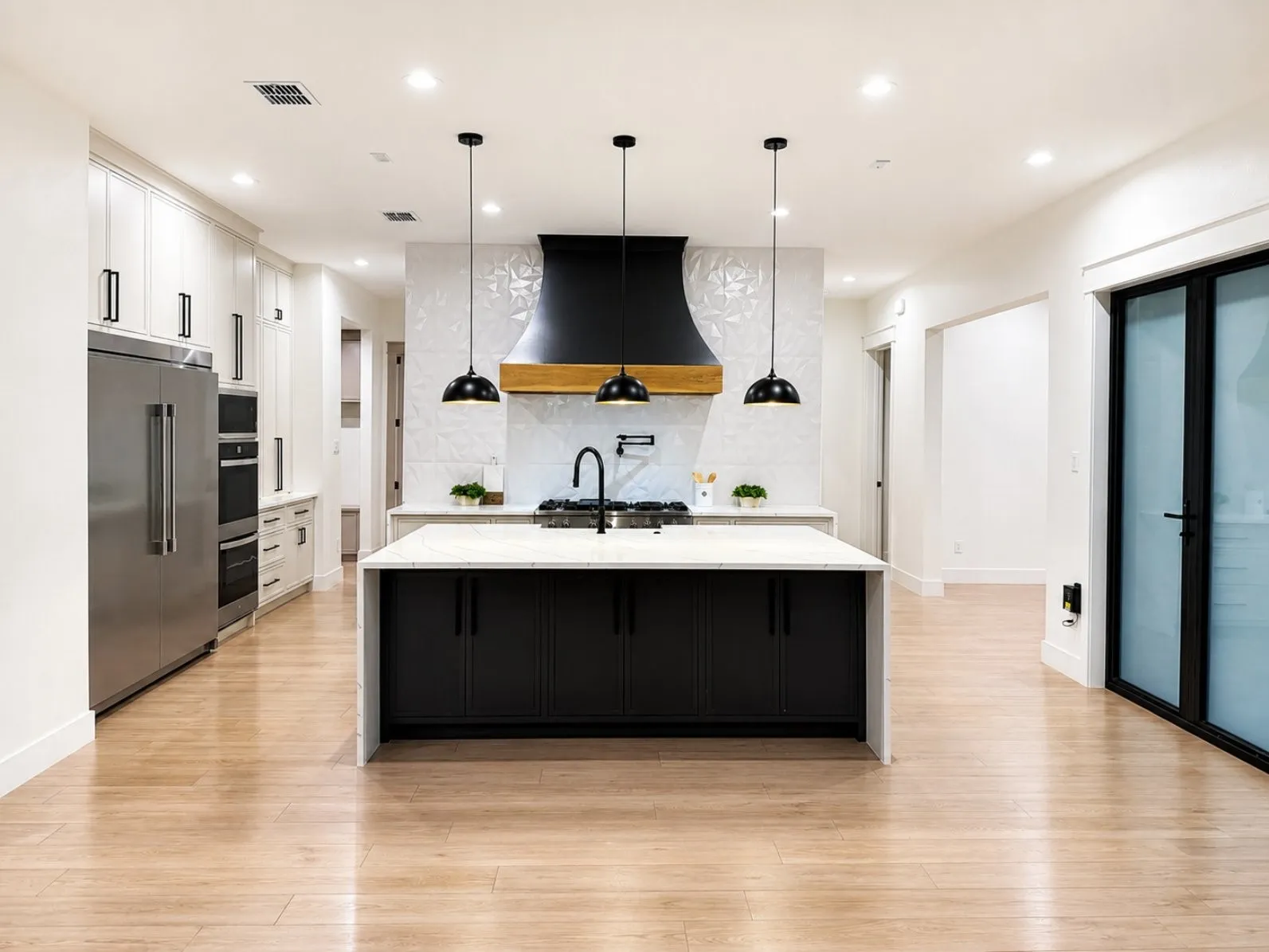 Modern kitchen featuring a waterfall island with a built-in sink and dark cabinetry