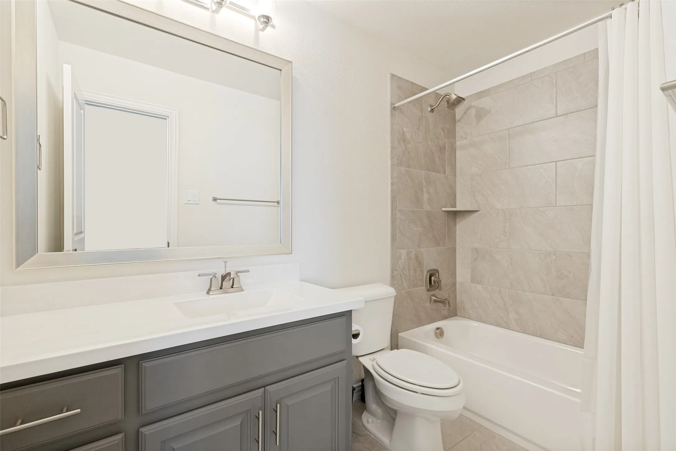 This upstairs bathroom is en-suite for the un-pictured bedroom.  It has similar features to the other baths, but has a taupe painted vanity and floor tile in as a tub surround.